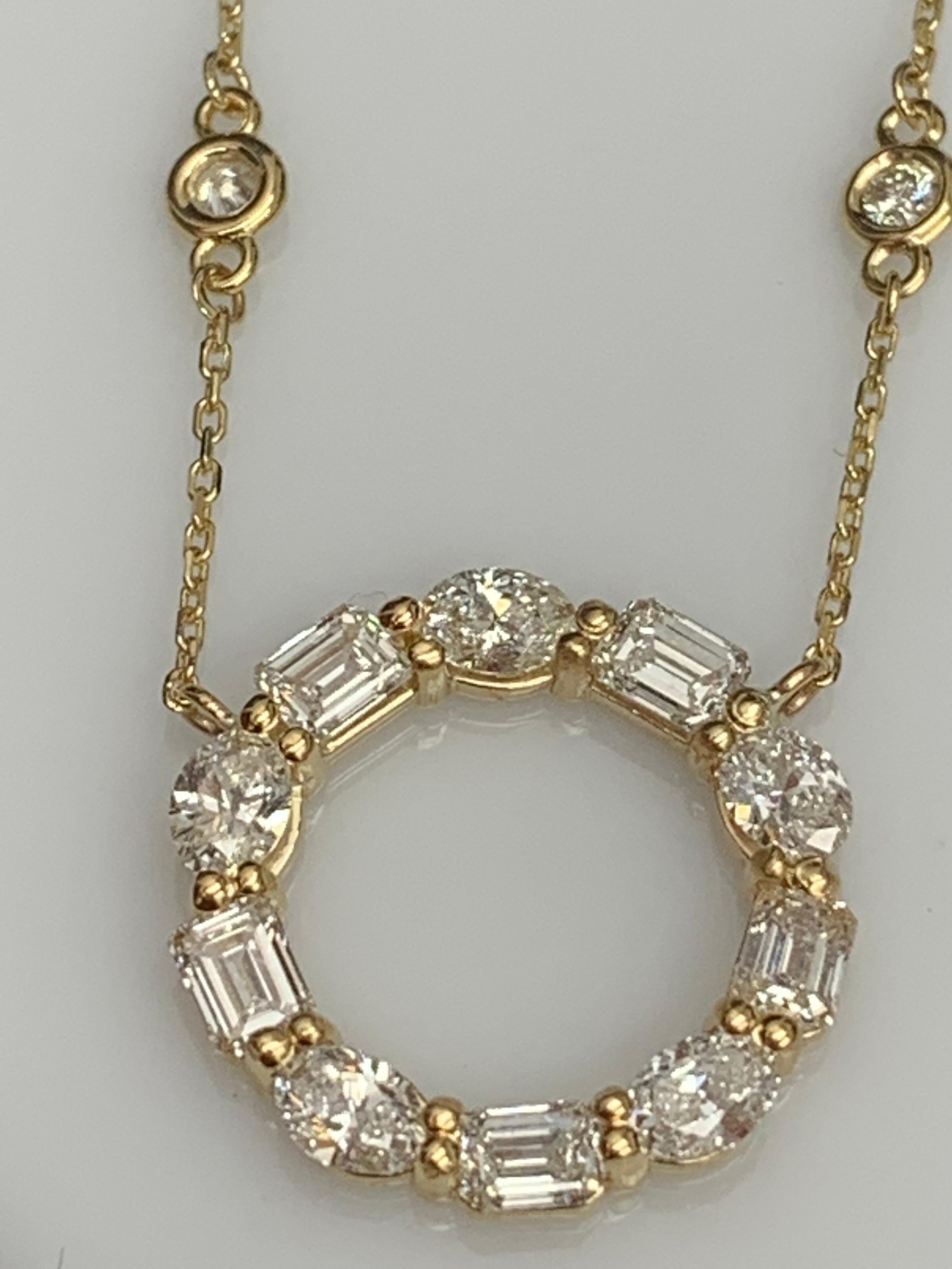 Un collier pendentif élégant mettant en valeur une rangée de diamants de formes différentes, sertis dans un design circulaire ajouré. 5 diamants de forme ovale pèsent 0.92 et 5 diamants de taille émeraude pèsent 0.97 carats au total. Tous les