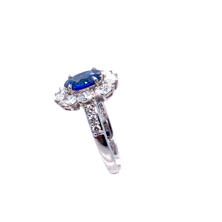 This ring has a 1.89 carat oval cut Ceylon sapphire center, surrounded by a halo of oval cut diamonds. Additional round diamonds decorate the side shank. Total diamond weight 1.53 carats. Set in 18k White Gold

Center: 1.89 carat oval cut ceylon