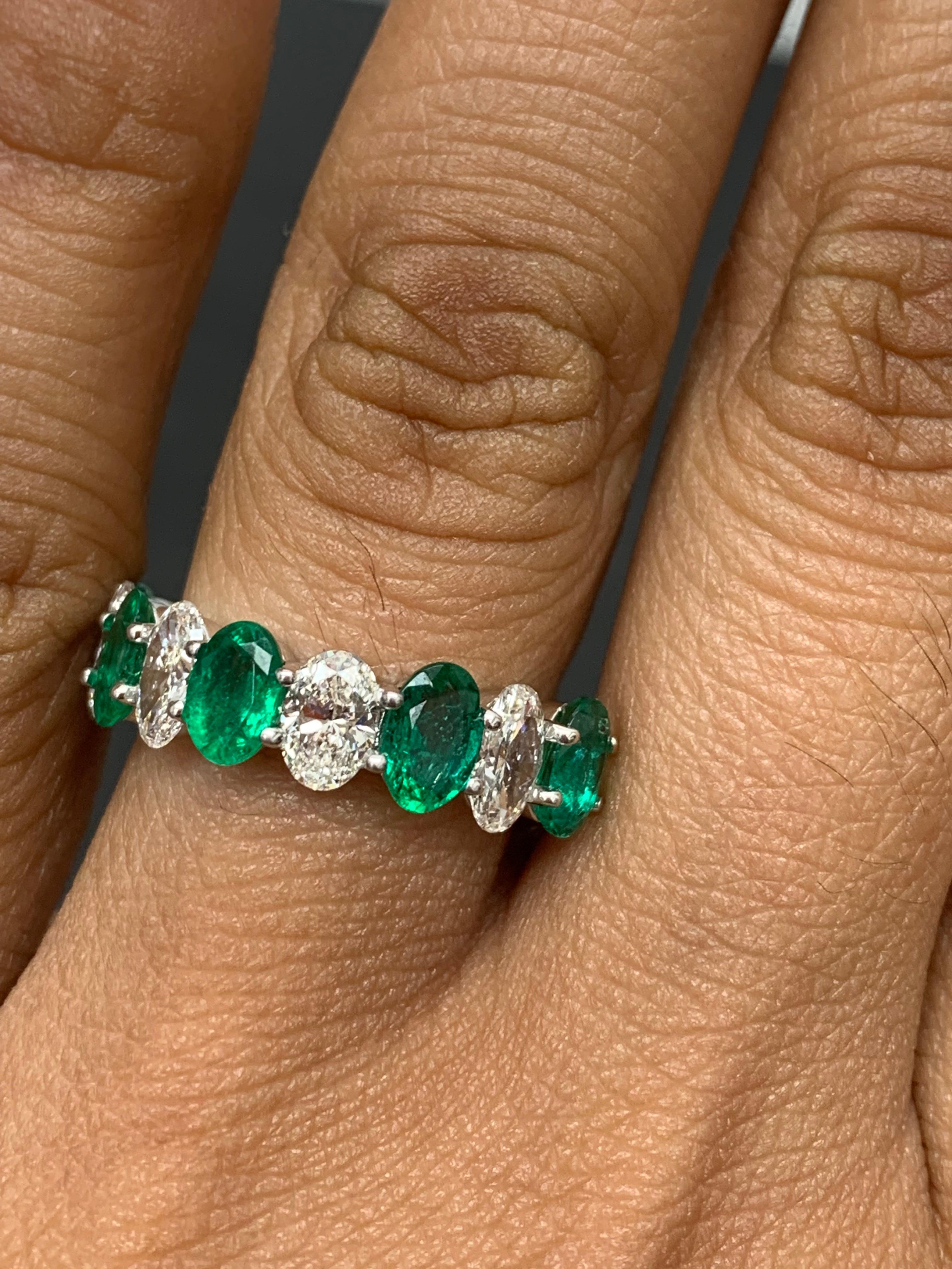 A fascinating gemstone wedding band 9 stone style showcasing lush green 5 oval cut emeralds weighing 1.89 carats total, alternating to these emeralds are 4 oval cut brilliant colorless diamonds weighing 1.26 carats, Made in 14K White Gold, Size 6.5