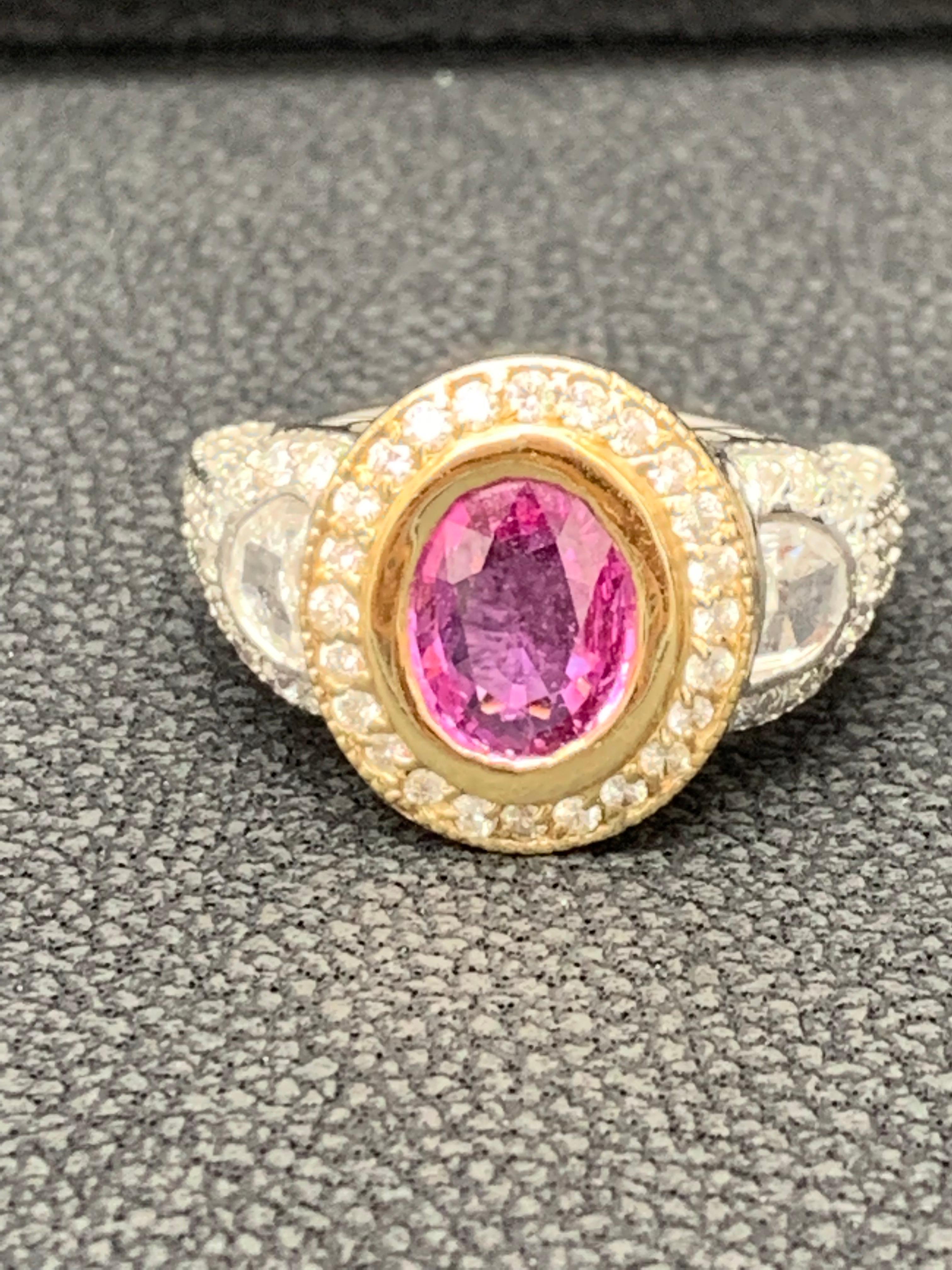 A vibrant and color-rich oval cut 1.89 carat pink sapphire takes center stage as it is elegantly set in a diamond encrusted halo in Yellow Gold and is accented with epaulette diamonds on each side.  Diamonds weigh 0.99 carats total. A magnificent