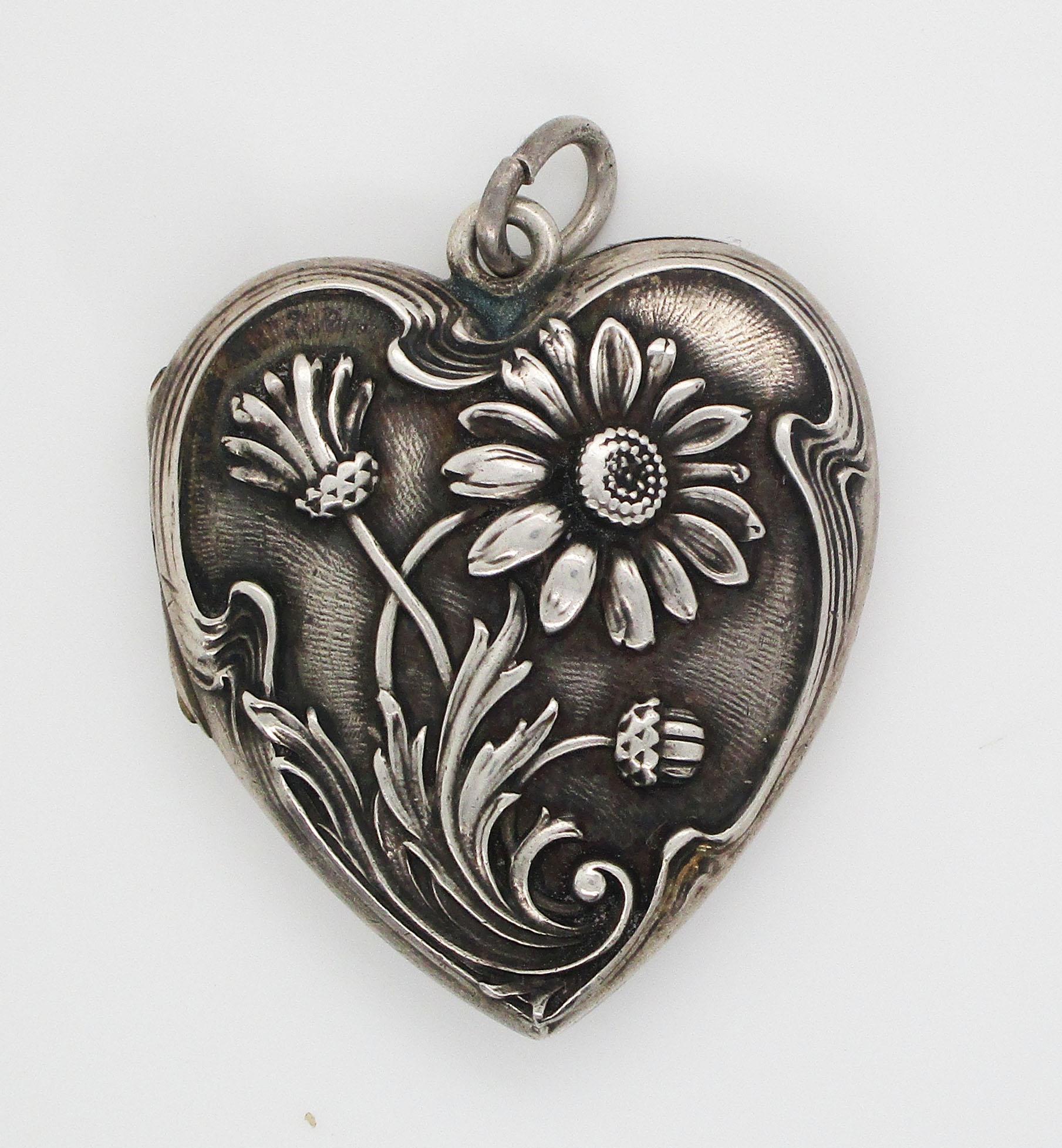 This beautiful Art Nouveau locket is in sterling silver and features a gorgeous flower design on a lovely heart shape! The front of the locket has a beautiful flower design with an excellent depth and a high contrast. The lines and design of the