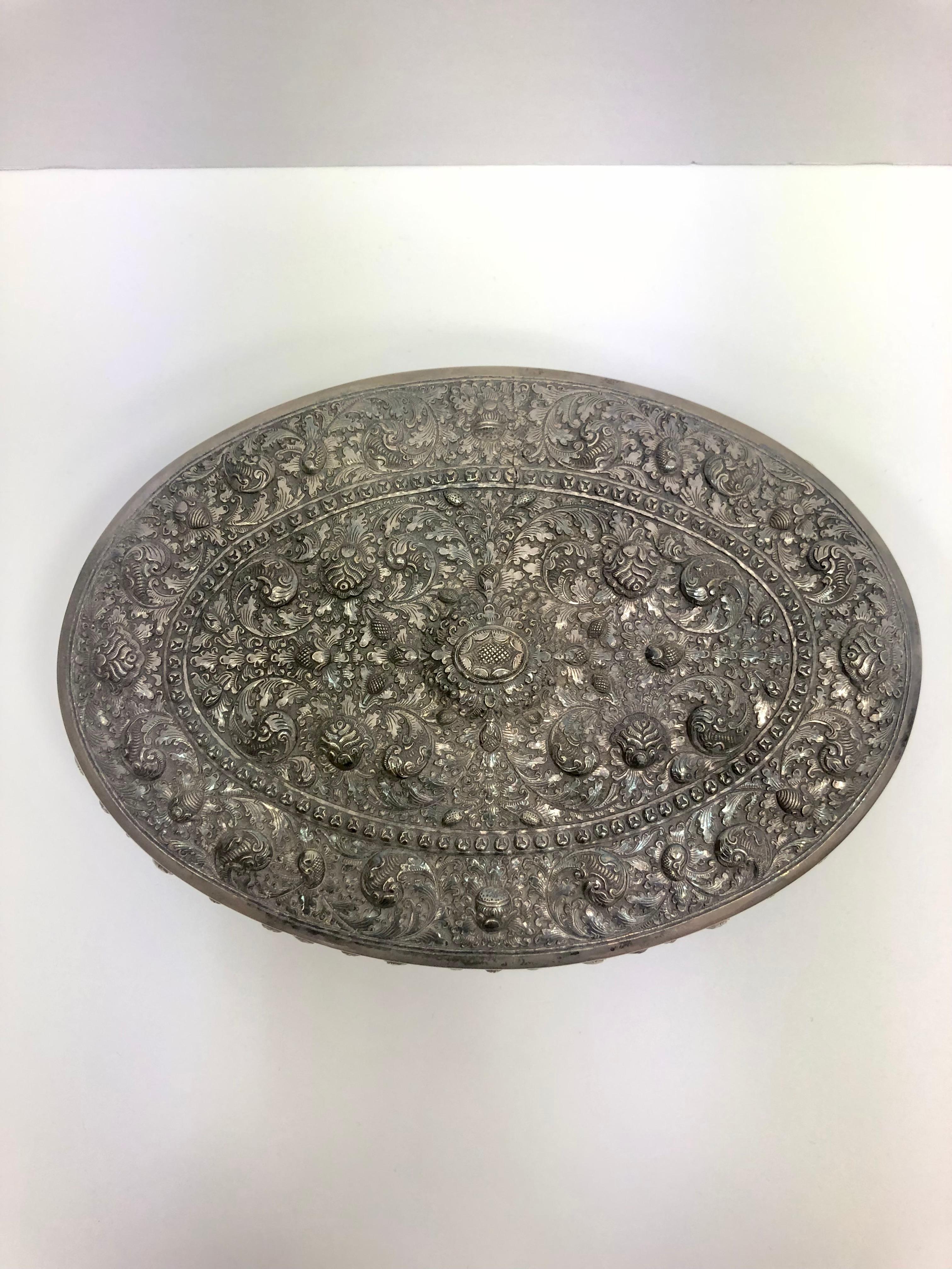 Ornate silver oval jewelry box with continental wood interior. Embossed ornate design and raised detail. Made with Egyptian 900 silver. 
Can be used as a jewelry, keepsake, trinket, vanity box. Made in Cambodia 1890. Marked Bounthan Cambodge T900.