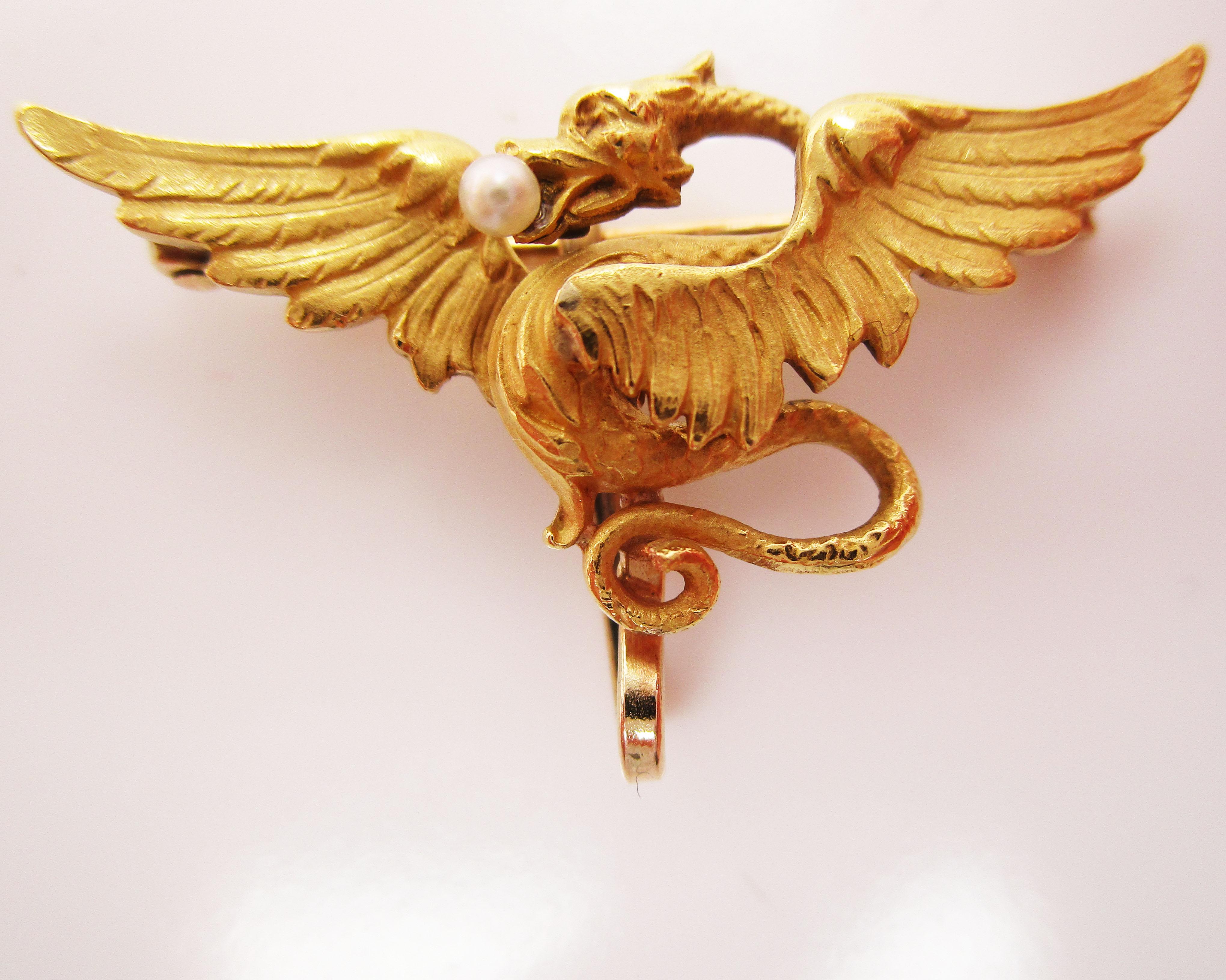 This is a magnificent Victorian watch holder pin by Krementz featuring a fantastic dragon design and a pearl accent! The design of the pin is reminiscent of a pilot’s wings pin, but featuring a majestic dragon with wings spread and a dramatically