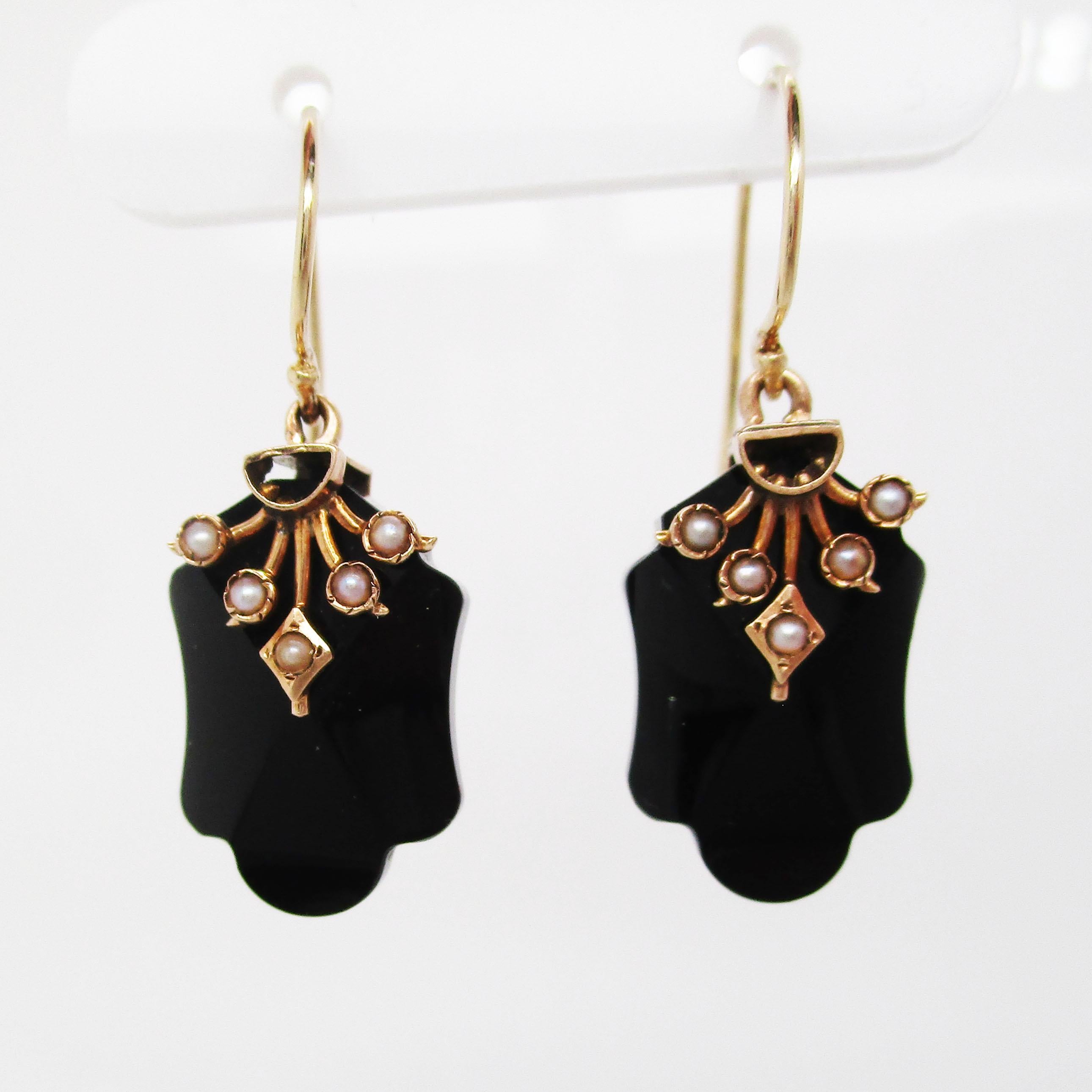 These beautiful Victorian earrings are in 14k rose gold and feature a black onyx dangle decorated with subtle, bright white seed pearl accents! These earrings have an elegant layout that is distinctly Victorian. The onyx has a curving lower end that