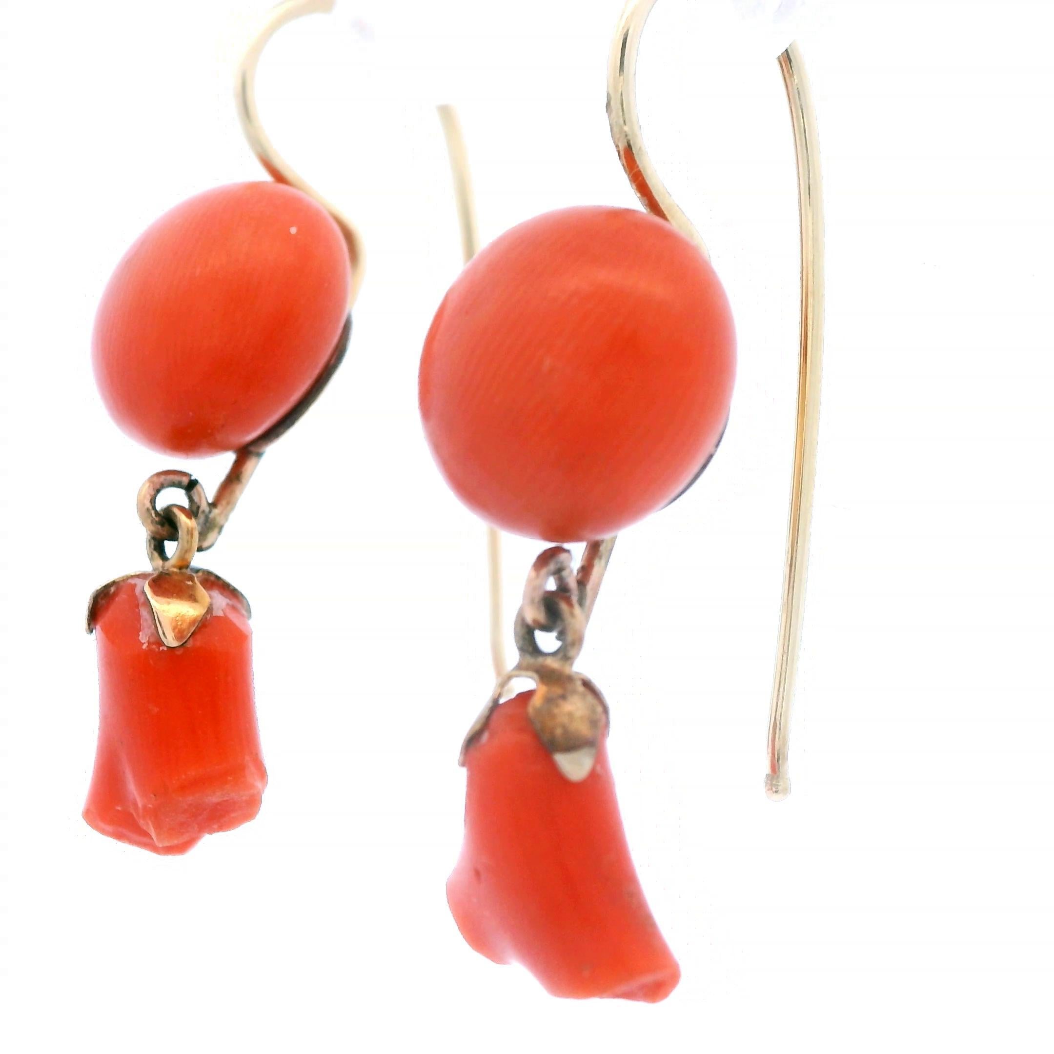 This is an extraordinary pair of natural coral floral earrings, made in 14k yellow gold, from the 1890 Victorian period. Each earring contains a 10mm natural coral button, as well as a coral dangle. They boast a bright coral color that ensure these