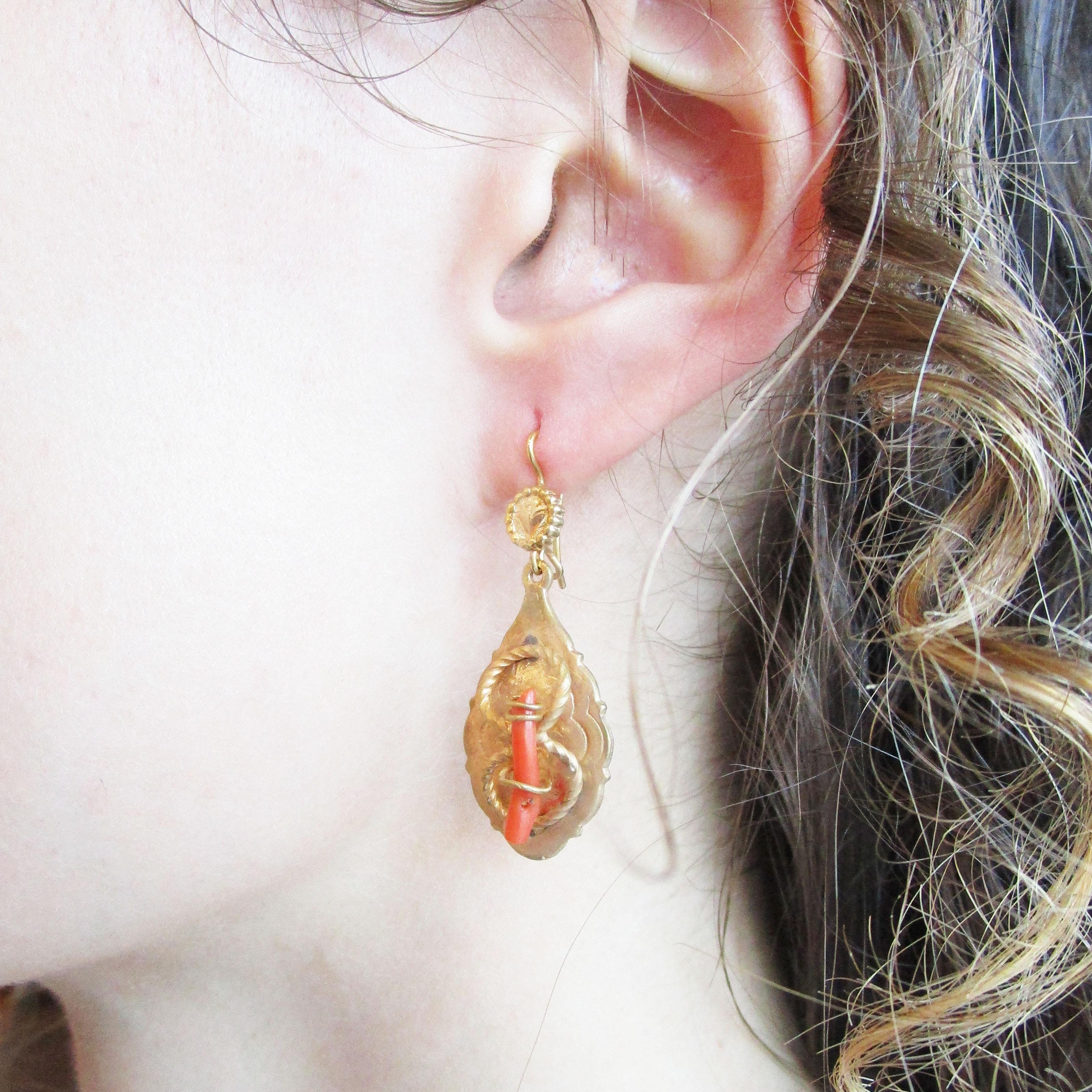 This is a stunning pair of Victorian dangle earrings dating from 1890 and featuring a gorgeous combination of gold-filled twist wire details and an undyed red coral branch center. The dangles have an elongated drop shape that flows well and is