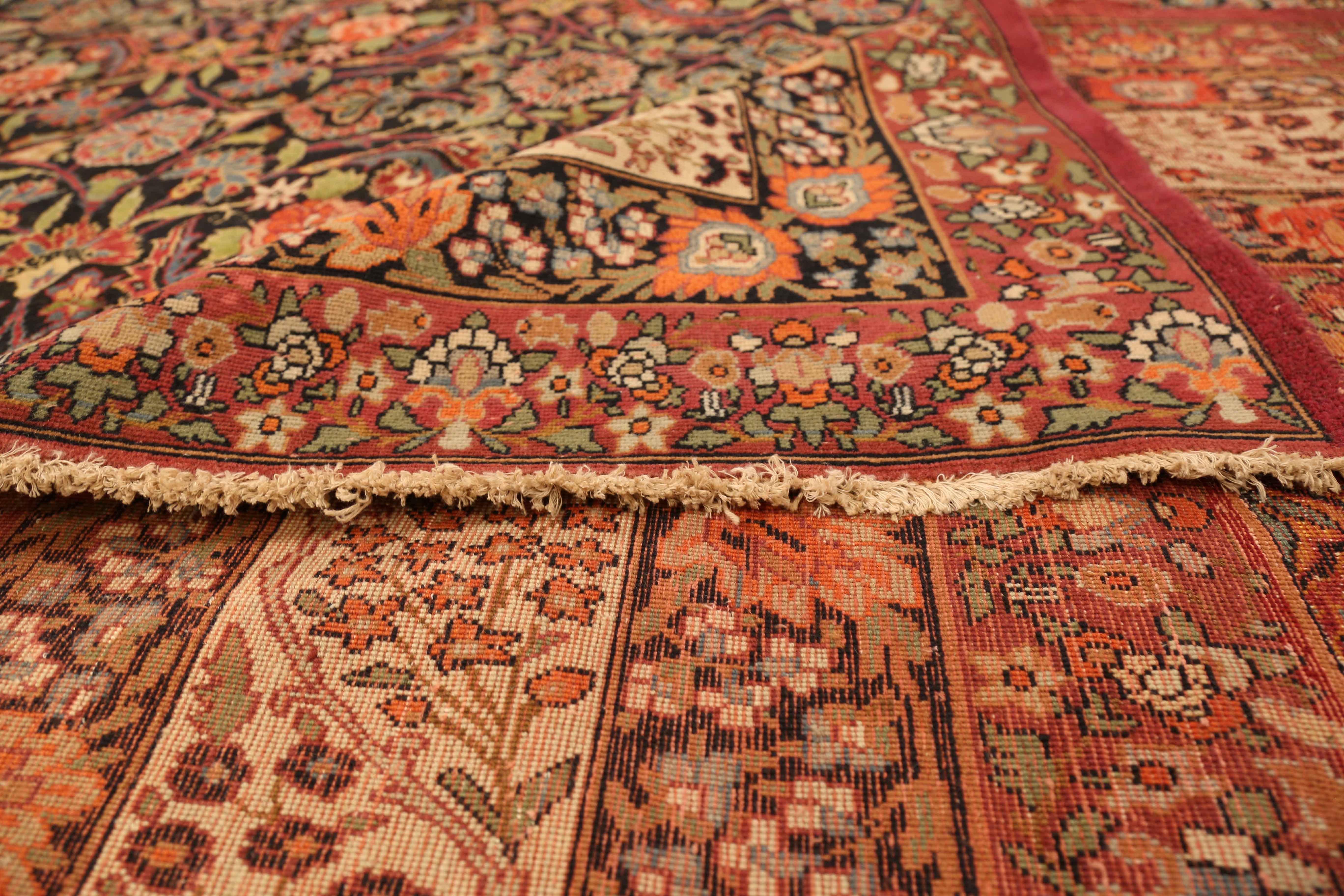 Antique Persian rug made in the 1890s by master weavers of the Kerman region. It was handwoven from the finest wool and rich organic dyes locally sourced and produced. It features intricately woven flower patterns in green, red and blue over a black