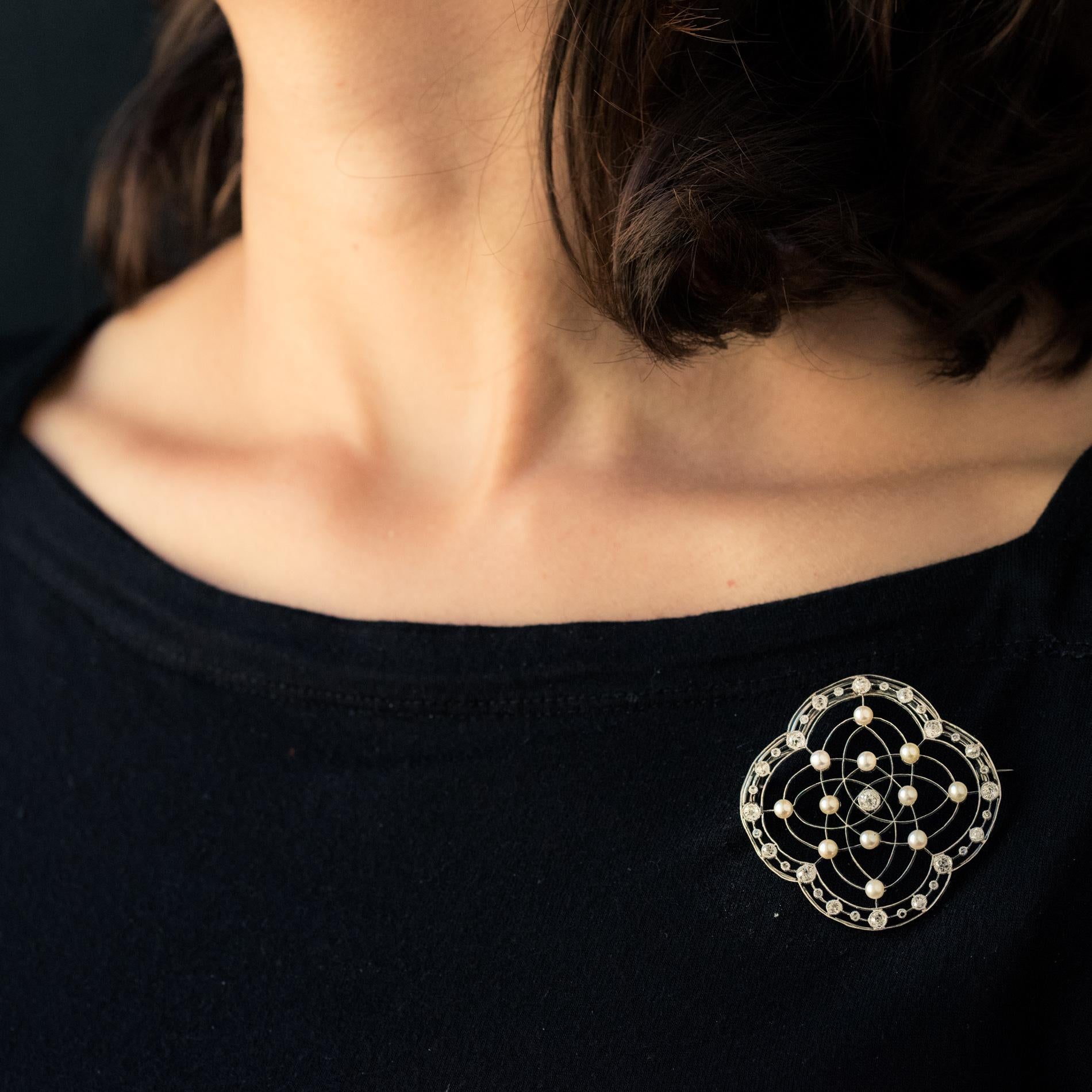 Broche de platino, sello de mascarón.
De forma cuadrilobulada, este suntuoso broche antiguo está fabricado con hilos de oro y platino sobre los que se engarzan 12 perlas naturales y un diamante antiguo talla brillante en engaste de perlas. Todo el