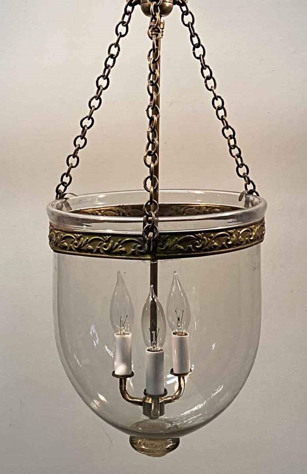 1890s English hand blown glass bell jar oil lantern with clear glass. Now electrified with brass hardware and three candlestick lights. This can be seen at our 400 Gilligan St location in Scranton. PA.