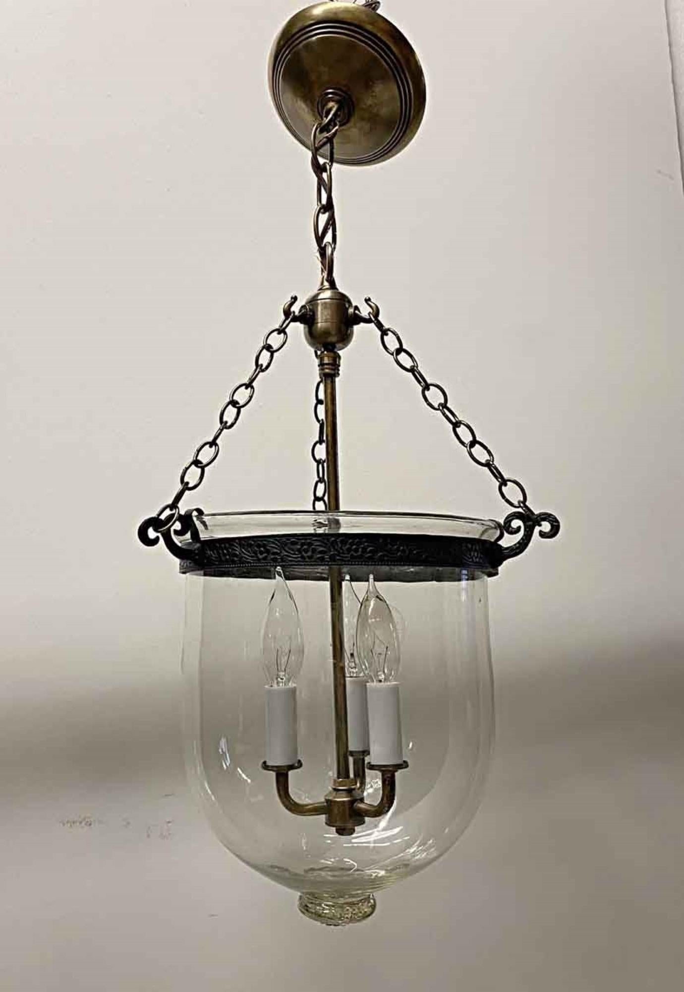 1890s English hand blown clear glass whale oil bell jar lantern. This fixture now features newly made brass hardware and three candelabra lights inside. This can be seen at our 400 Gilligan St location in Scranton. PA.
