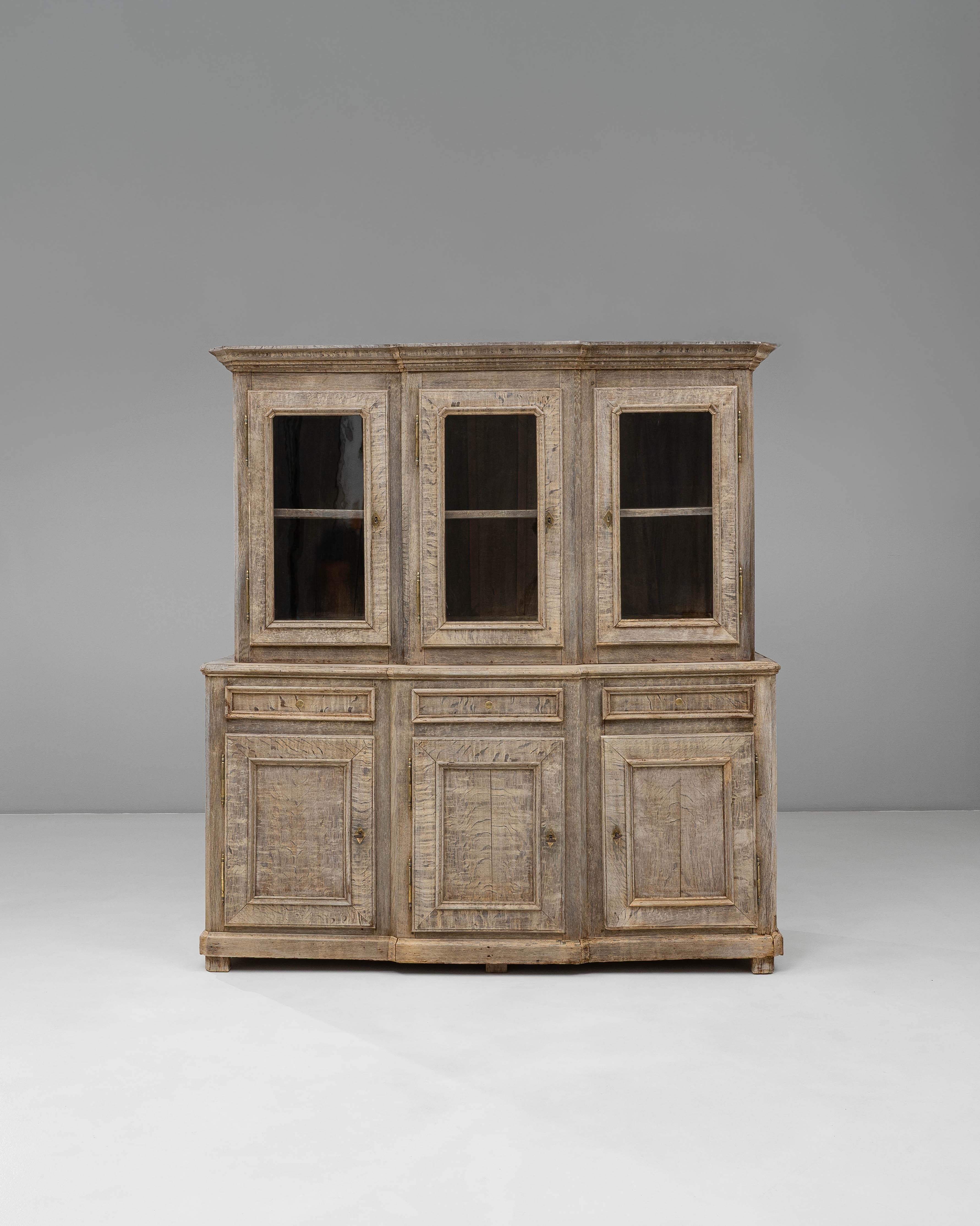 Diese Vitrine aus französischer Provinzeiche aus den 1890er Jahren zeigt die rustikale Eleganz und Handwerkskunst des ländlichen Frankreichs des späten 19. Der obere Teil verfügt über drei Glastüren mit Innenregalen, die sich ideal zur Präsentation