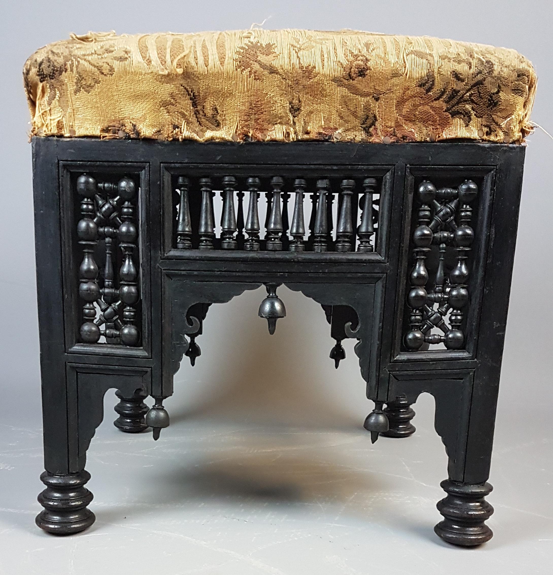 A lovely late 19th century Liberty's Mashrabiya stool with original ebonized finish and original fabric. The designer of this stool is unknown but it was retailed by Liberty's in London and is also in the book 'Liberty's Furniture 1875-1915, The