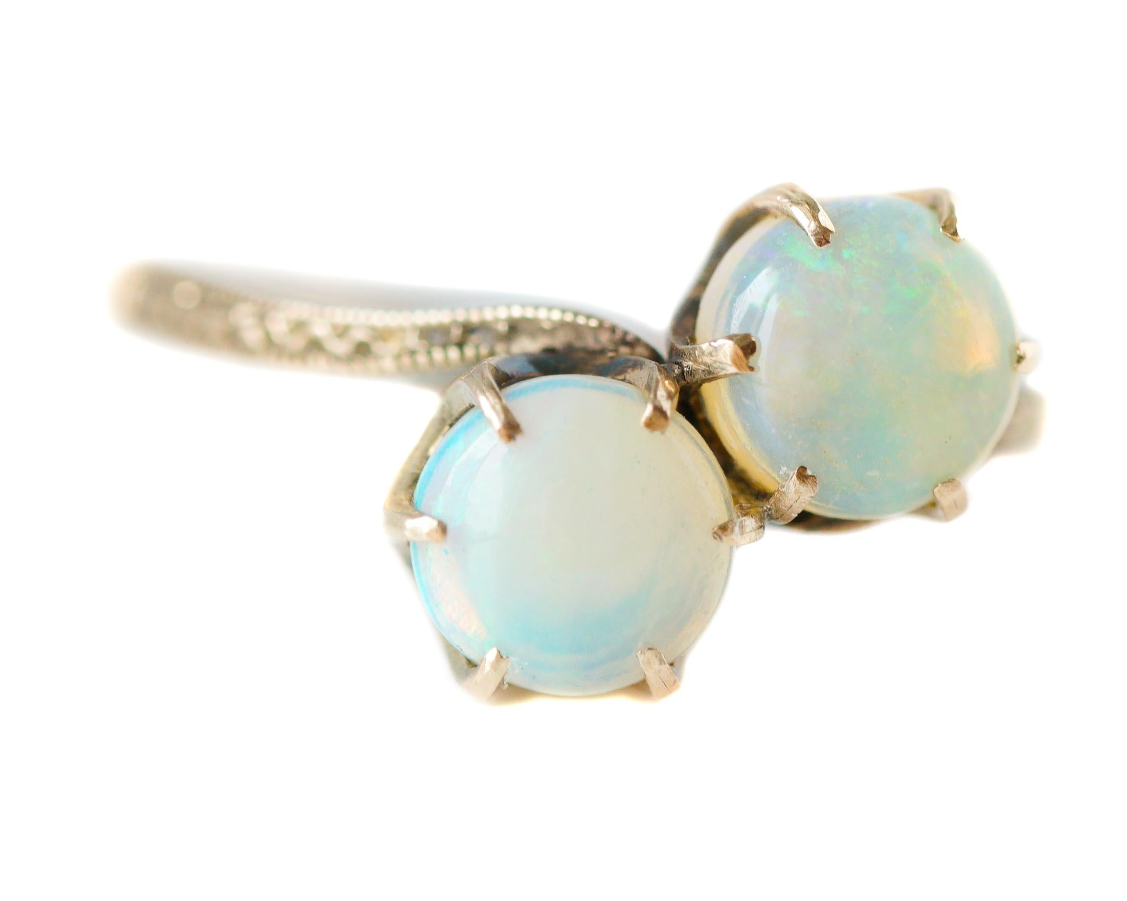 This gorgeous Opal Ring features a delicate bypass setting. 
The front half of the shank is embellished with an elegant, hand-etched design flanked by migraine detail along the upper and lower edges. The 14 karat Rose Gold beautifully accents the 2