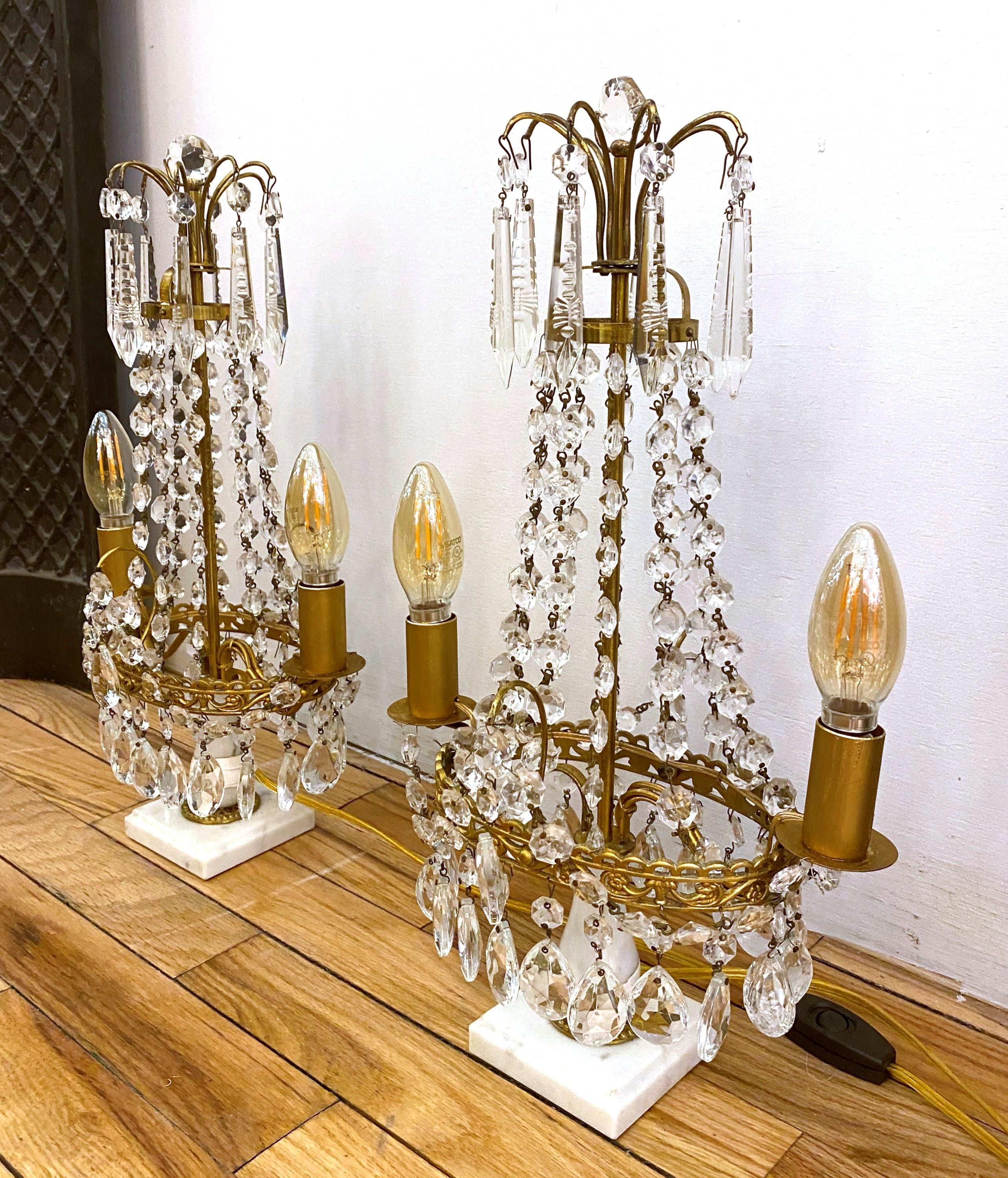1890s Swedish Gustavian style pair of two light candelabra crystal and brass table lamps featuring a white marble base each. These have now been converted to electric. Each light takes two candelabra light bulbs. Cleaned and restored. Priced as a