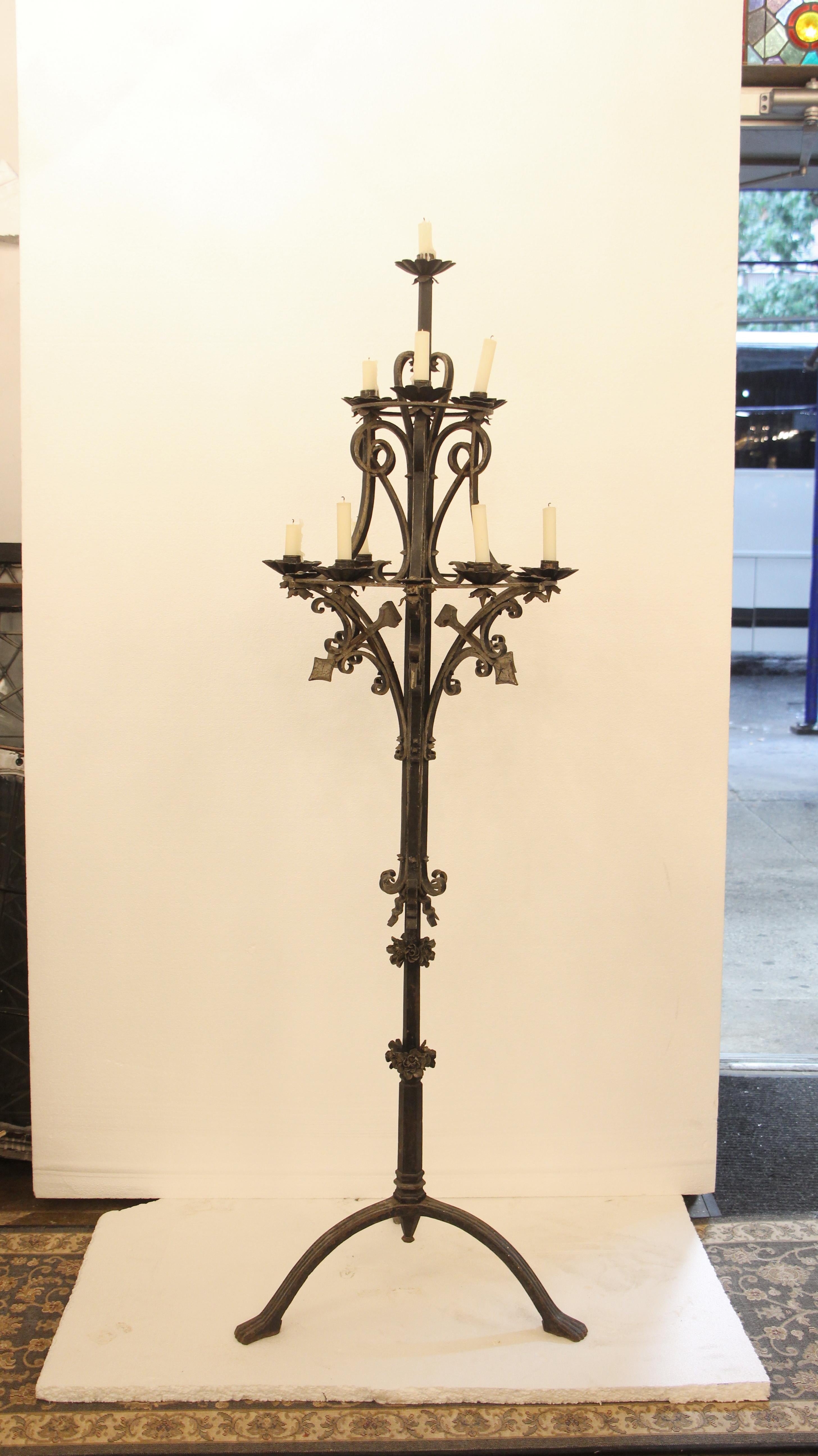 Late 1800s hand wrought iron candelabra lamps with a black finish. Each lamp holds 10 candles. There is a piece of floral detail missing on the bottom. Priced as a pair. Please note, this item is located in our Los Angeles, CA location.