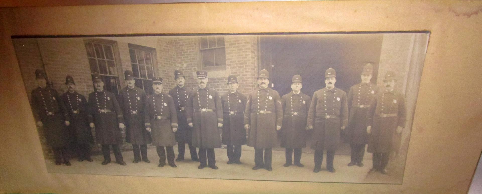 Rare panorama framed photograph of 13 United States police officers in full uniform. Circa 1907. The old wooden frame painted black appears to be the original and measures .75 inches wide. The photograph itself measure 20.50 inches wide x 8 inches