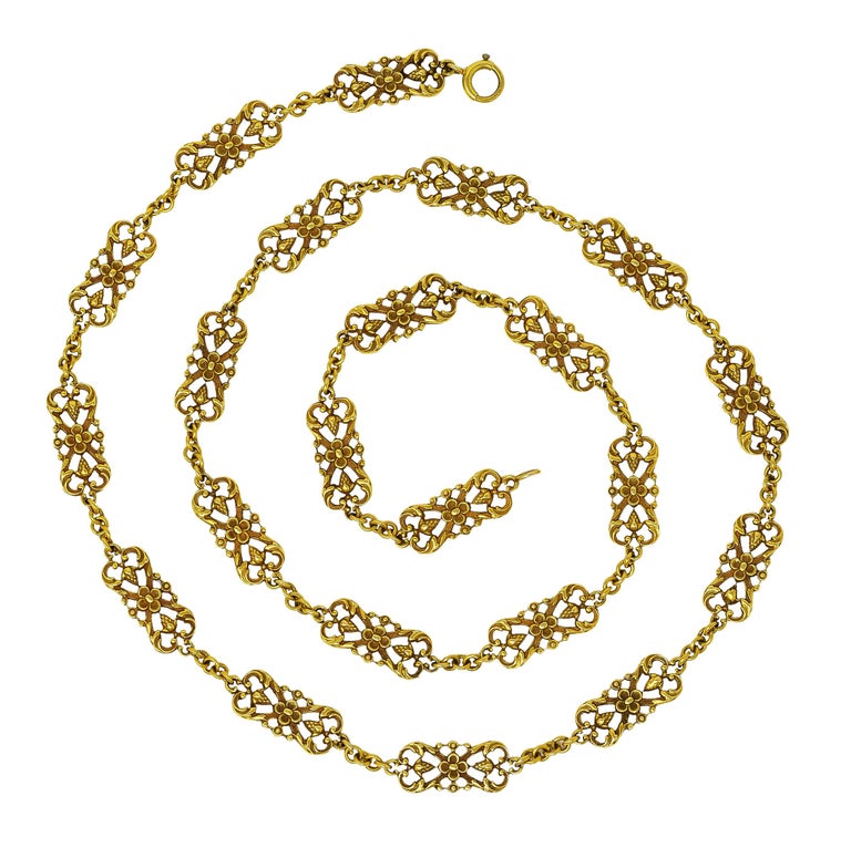 Chain necklace is comprised of deeply stylized pierced links. With highly rendered scrolling floral and pinecone motifs. Alternating with cable style links. Completed by large spring clasp closure. Stamped 14 and tested as 14 karat gold. Circa:
