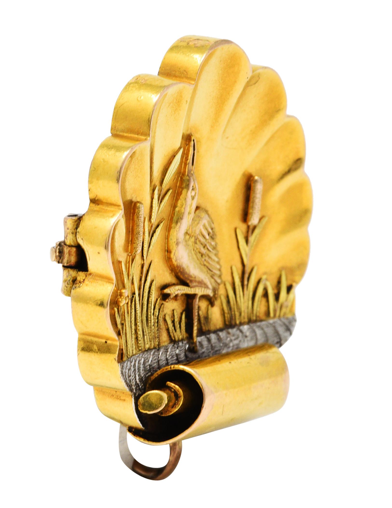 Designed as a scalloped shell with a scrolled volute base

Depicting a serene scene of a heron perching on one leg amidst white gold waters

Surrounded by green gold foliate and rose gold cattails

Completed by a pin stem with closure and a watch