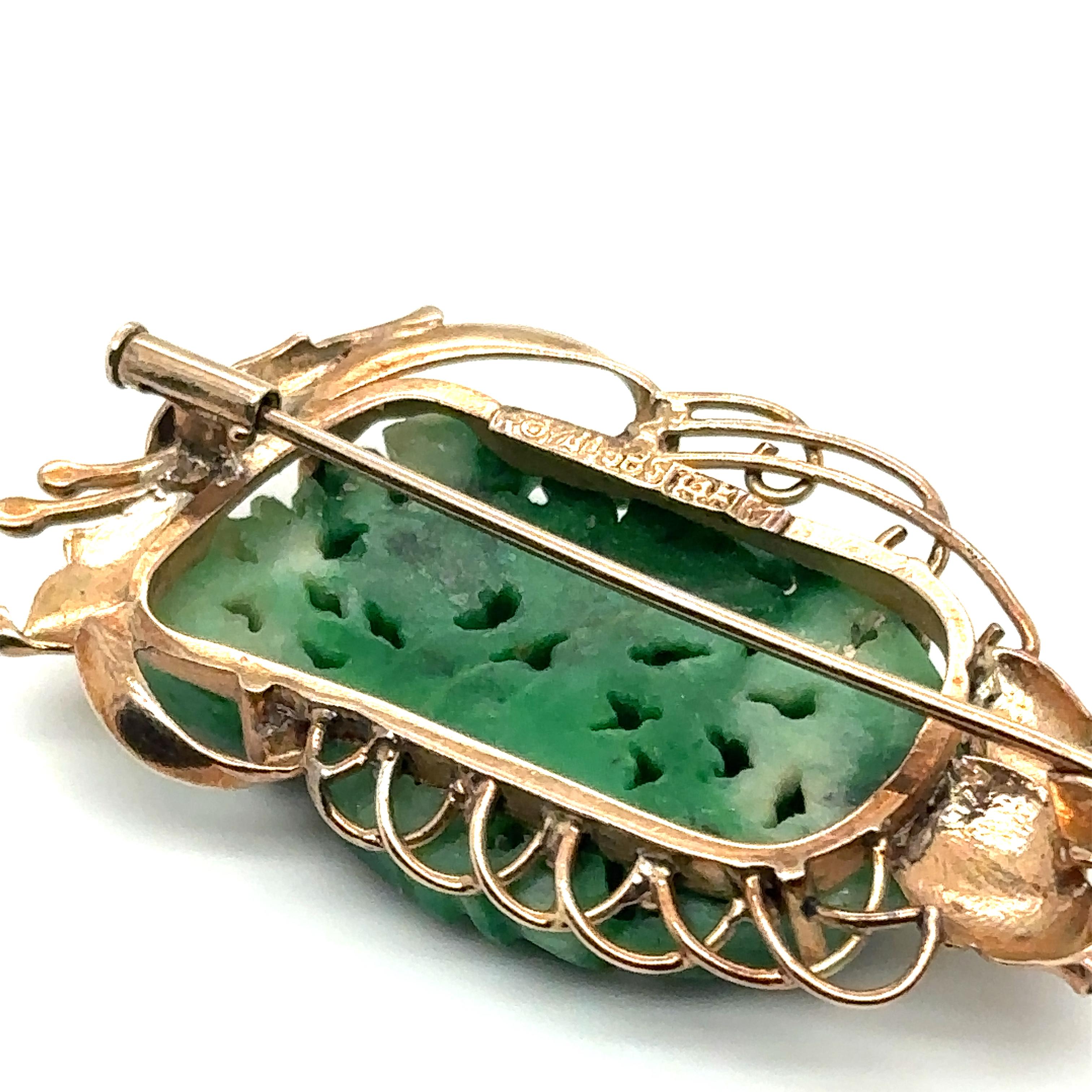Item Details: This brooch, originating from Victorian Asia, features a beautiful green carved jade and a decorated gold design.

Circa: 1890s
Metal Type: 14 Karat Yellow Gold
Weight: 9.2 grams
Size: 1.75 inch Width 

Hallmarked: 