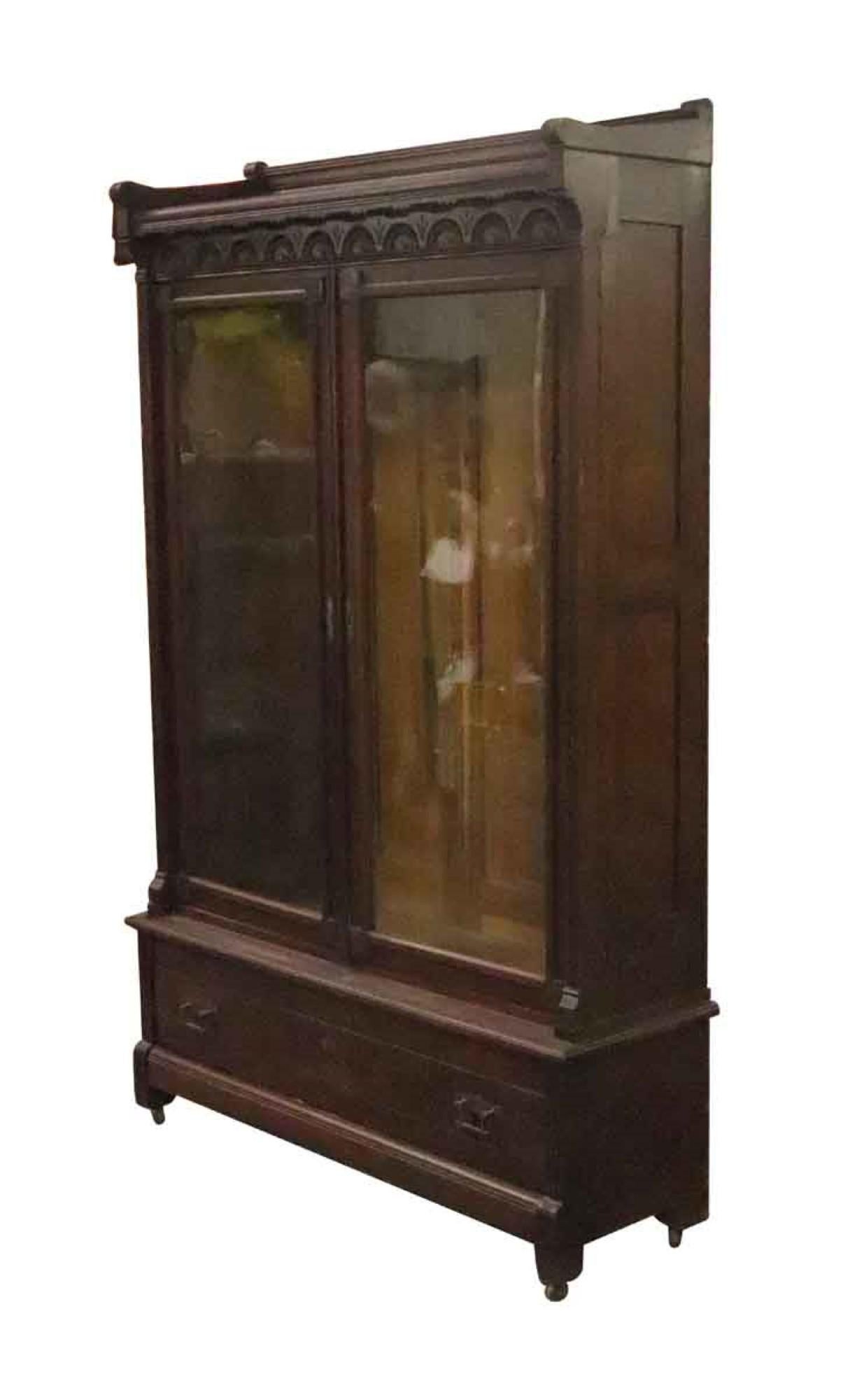 Librería victoriana de dos puertas de nogal en tono oscuro de la década de 1890. Dos puertas delanteras con cristal y herrajes originales de latón. Cinco estantes de madera regulables.