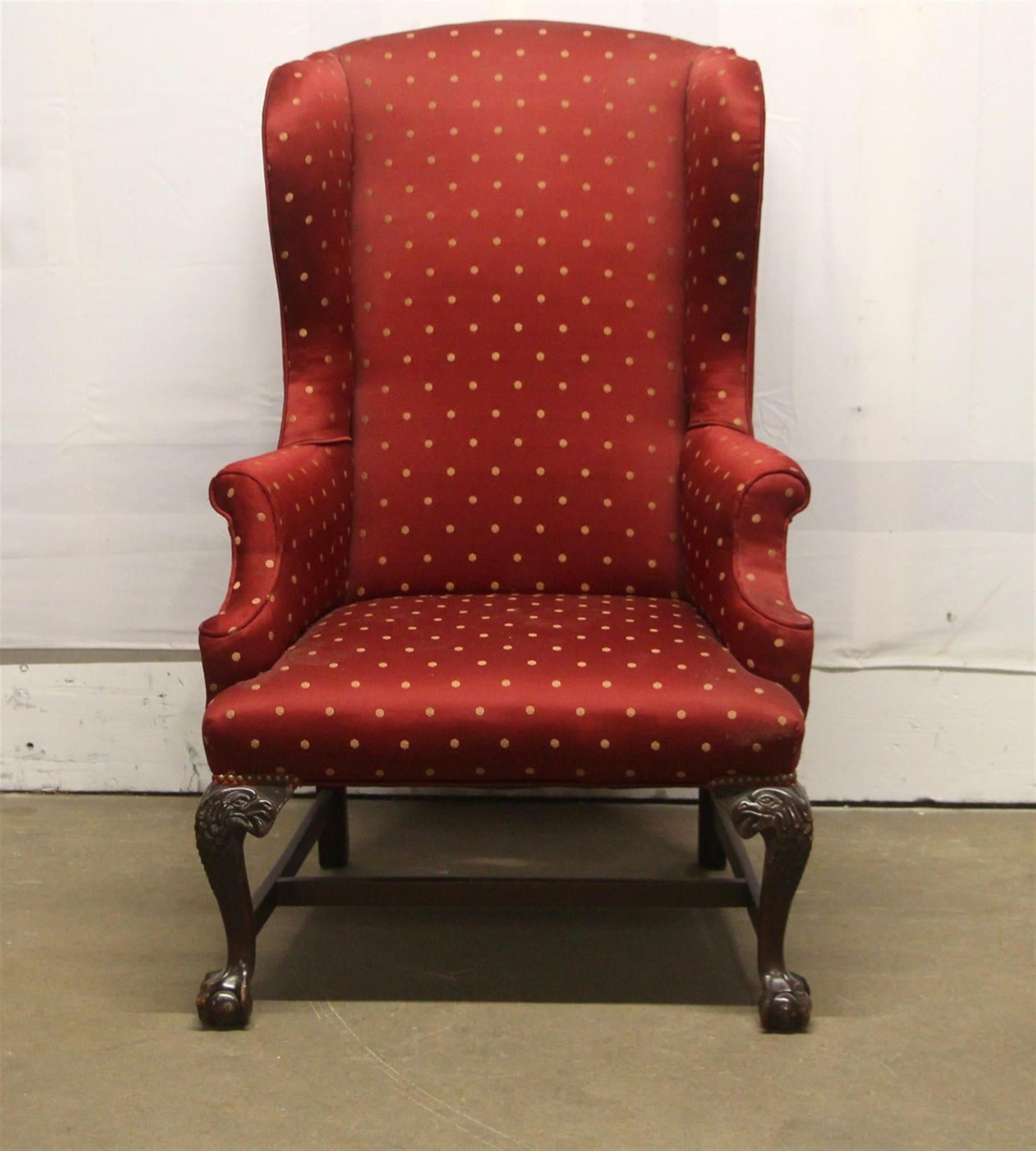 1890s carved wood wing back chair with newly reupholstered deep red gold dotted upholstery. Dark wood tone frame with carved figural legs. There is general wear from age and use. This can be seen at our 302 Bowery location in NoHo in Manhattan