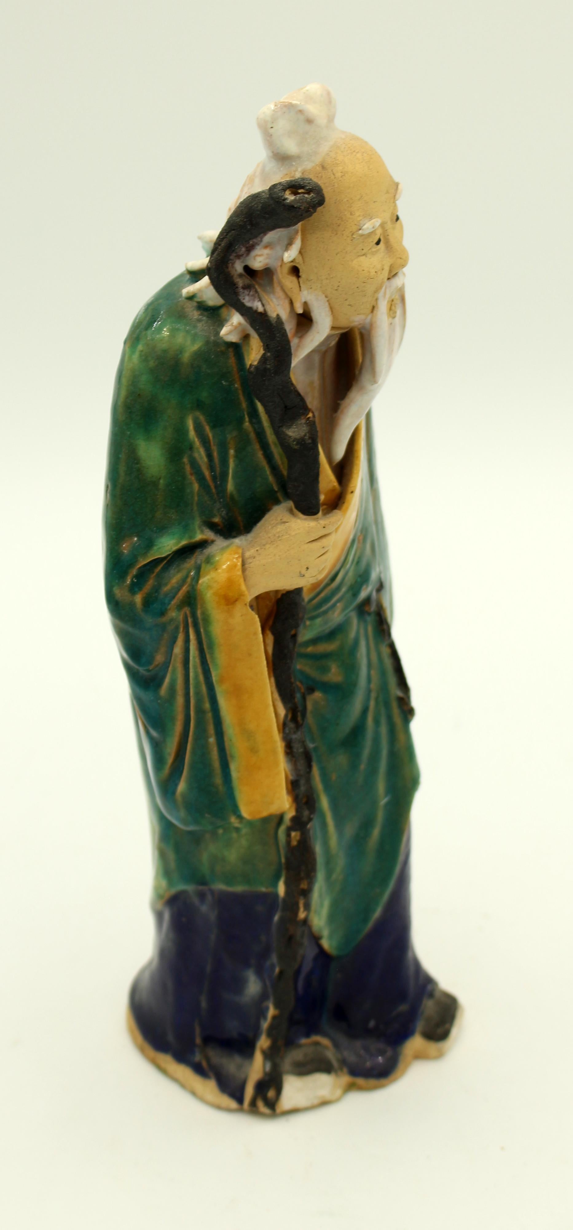 1892-1904 large Chinese mud man figure, an elder with staff in flowing green & yellow robe. Stamped 