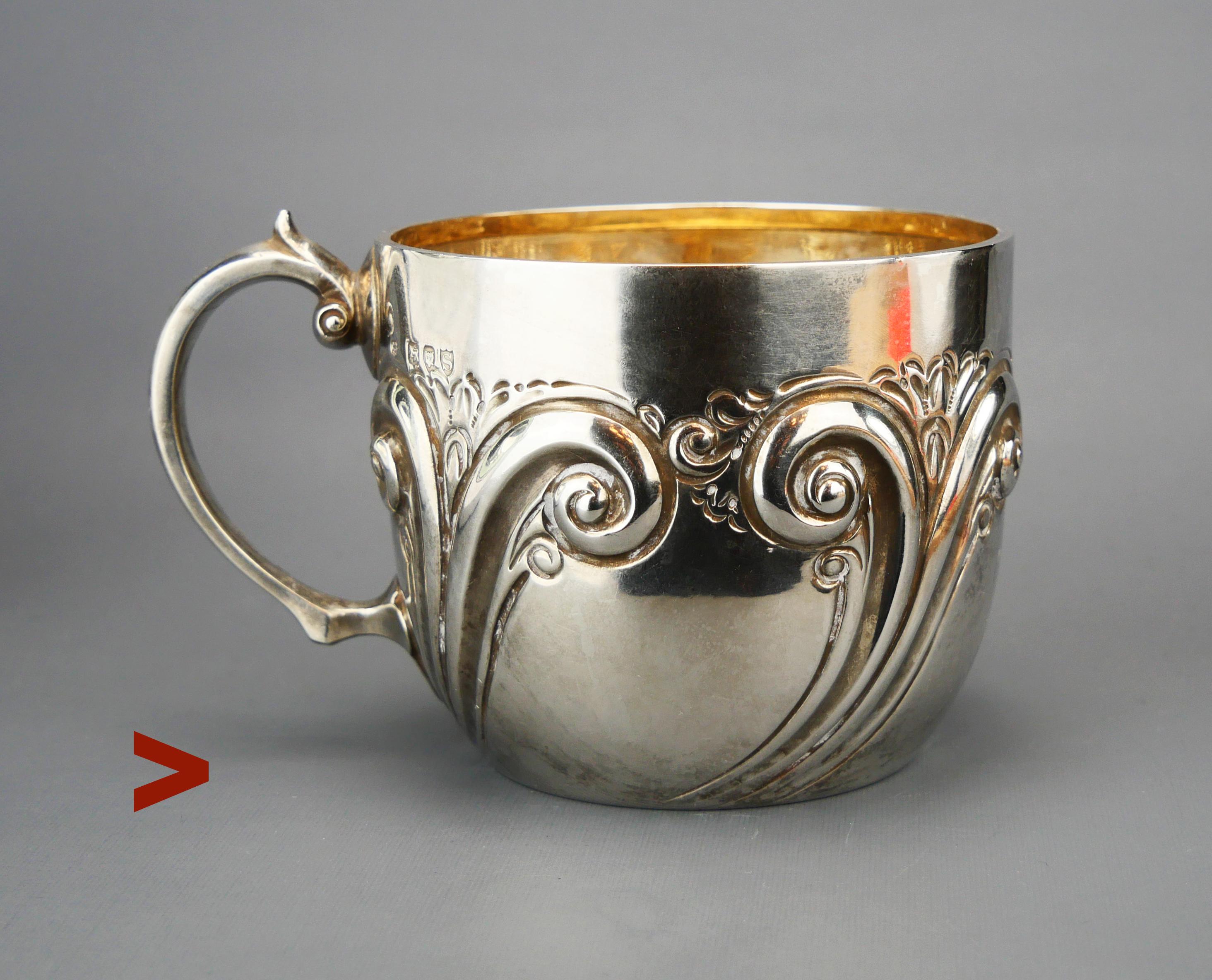 Coppa vittoriana in argento sterling, con pareti spesse e ornamenti continui su tutti i lati. 
Doratura interna ben conservata.

Questa tazza ha una serie completa di marchi convenzionali britannici: il produttore è Charles Edwards, il marchio della