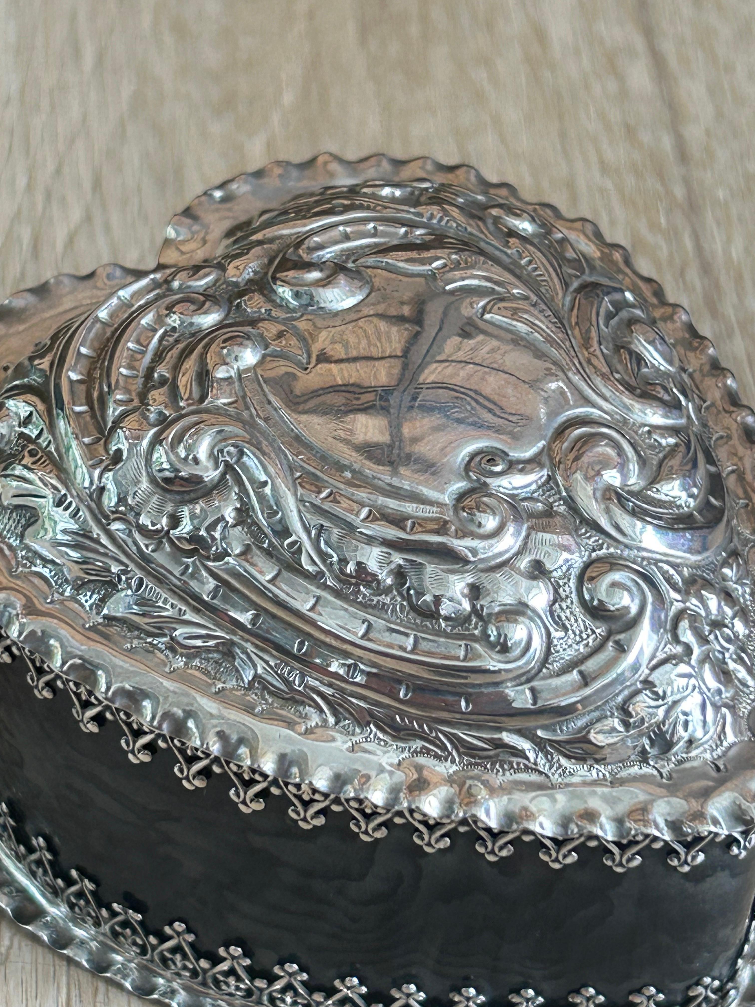 Silver and Tortoiseshell jewellery box in the shape of a heart with floral decoration on the lid, silver laces linking the silver parts to the tortoiseshell sides.

The pictures are part of the description.

Warning: Since this items are made of a