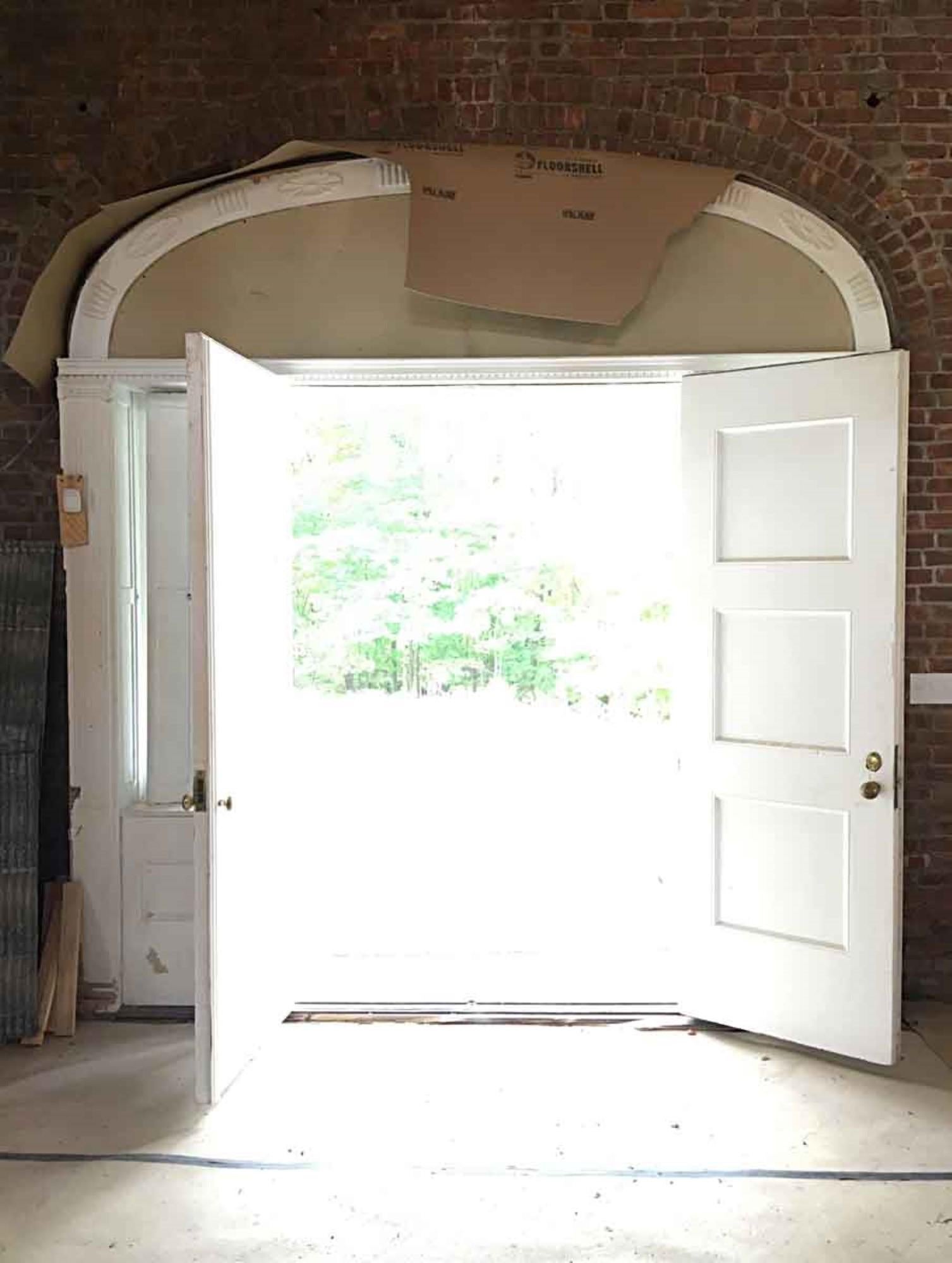 Late 19th century 1895 entryway complete with double doors, sidelights and arched transom of leaded glass, frame including pilasters with capitals, and shutters. This Georgian style entryway is salvaged from New York State. The double doors have