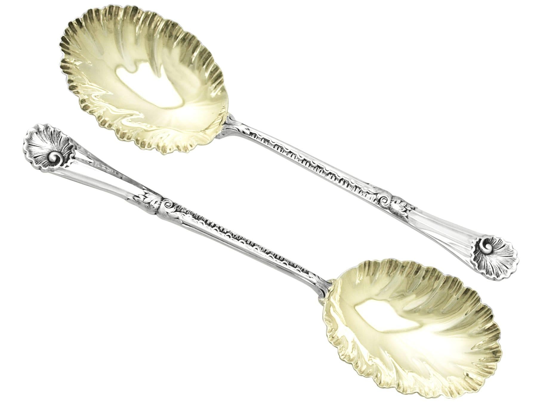 A fine and impressive pair of antique Victorian English sterling silver fruit spoons - boxed; an addition to our silver flatware collection.

These fine antique Victorian sterling silver fruit spoons have embossed shell shaped bowls onto tapering