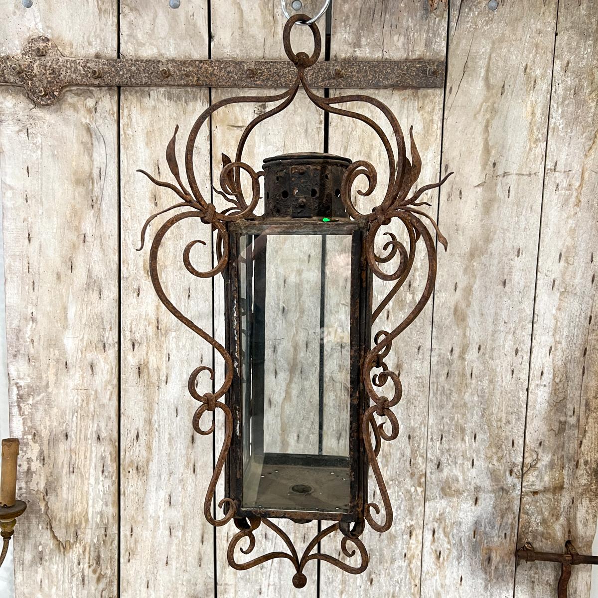 There is truly fine ironwork on this tall slender lantern.  Each corner has carefully wrought leaves and twisted spikes.  The tall, narrow size makes this piece perfect for the smaller space either inside or outside.  All glass is intact, one piece