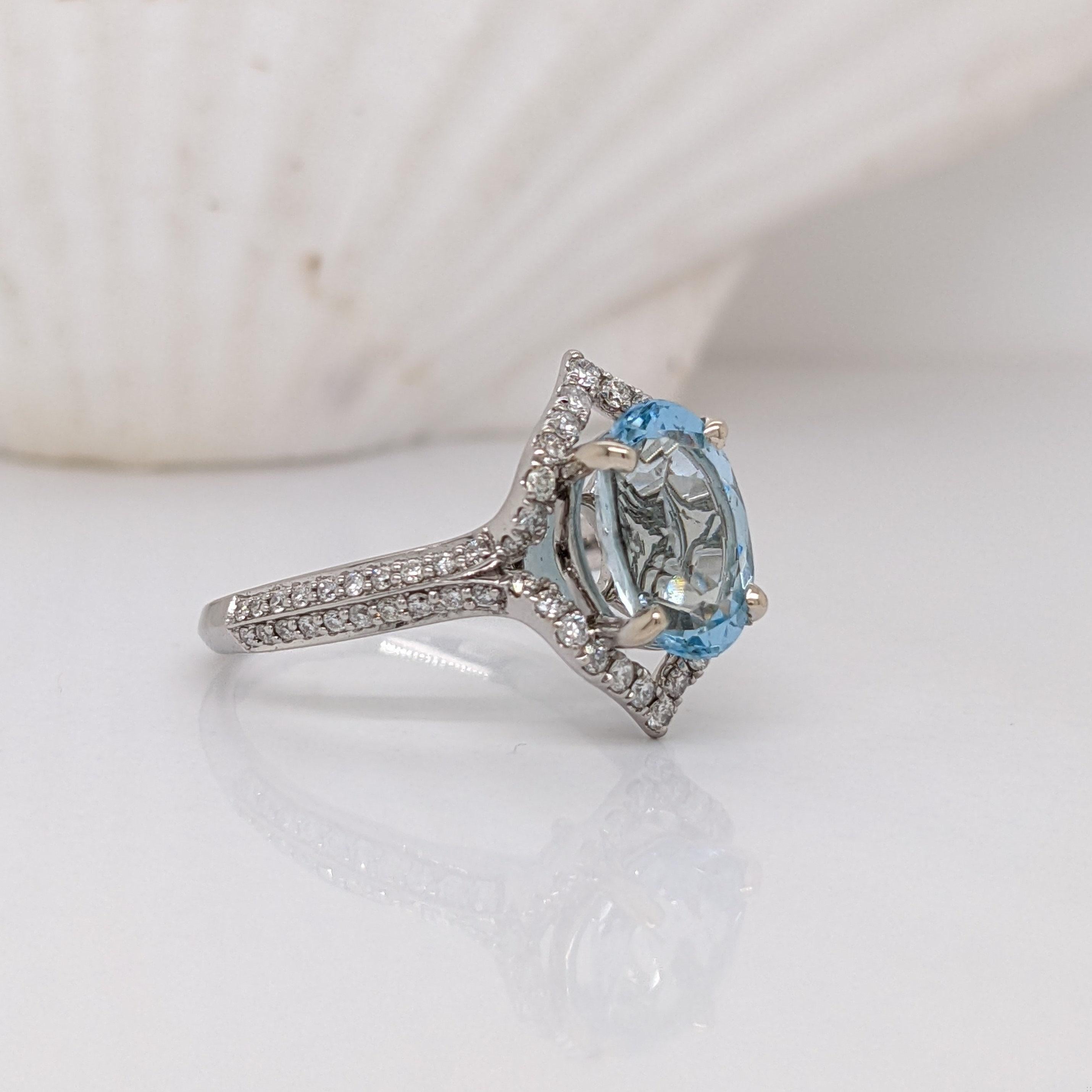 This statement ring features a brilliant blue oval aquamarine encased in a halo of natural earth mined diamonds.  Made in 14k gold, this ring boasts a stunning double pave split shank. A design perfect for an eye catching engagement or anniversary.