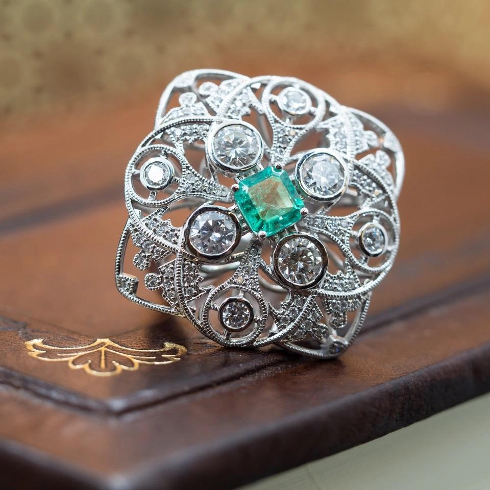 Description: 18ct Art Deco Style Emerald & 1.8ct TDW Diamond Cocktail Ring

This showstopping cocktail ring was designed and created by Monty's in a classic Art Deco style. It measures approximately 27mm across and is set with a emerald feature