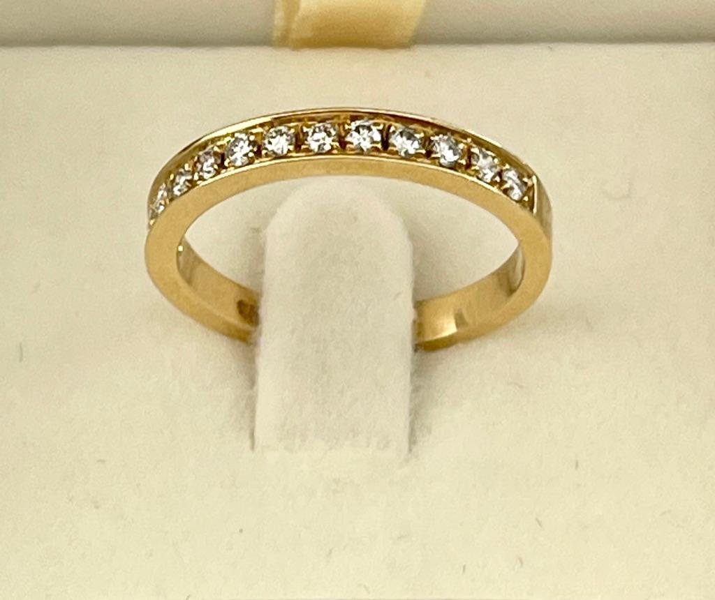 This ring features 13 x Natural Diamonds that are bead set in 18ct yellow gold. The ring is stamped 750 and is designed to sit comfortably against an engagement ring or it can be stacked against other bands to create a modern look. 
The diamonds are