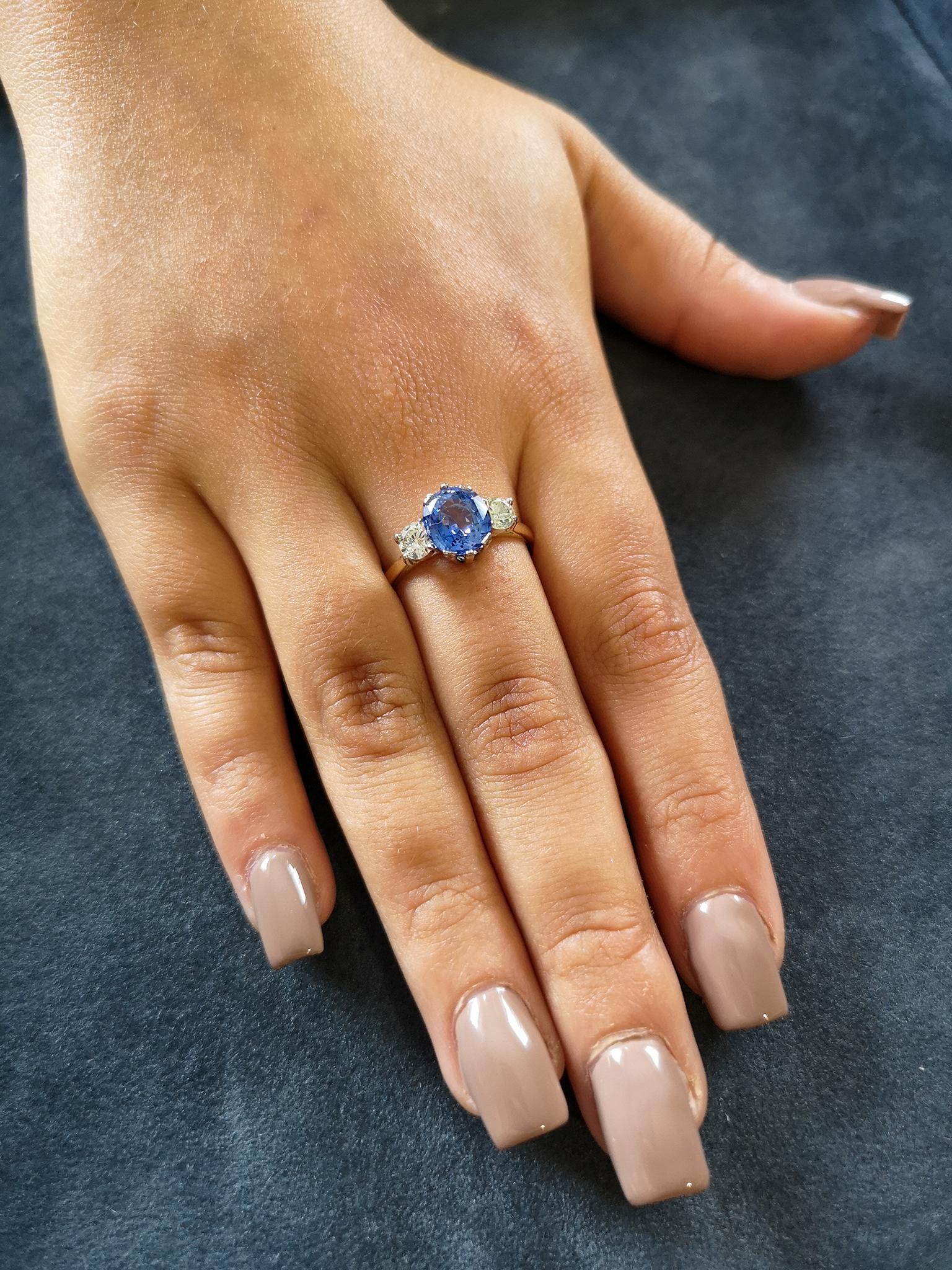 A fine and impressive 'cornflower blue' oval sapphire of approximately 2.00 carats, with exceptional colour and sparkle is mounted in 18-carat white gold double claws. Flanked on each side by a single brilliant-cut diamond, leading to a uniform,