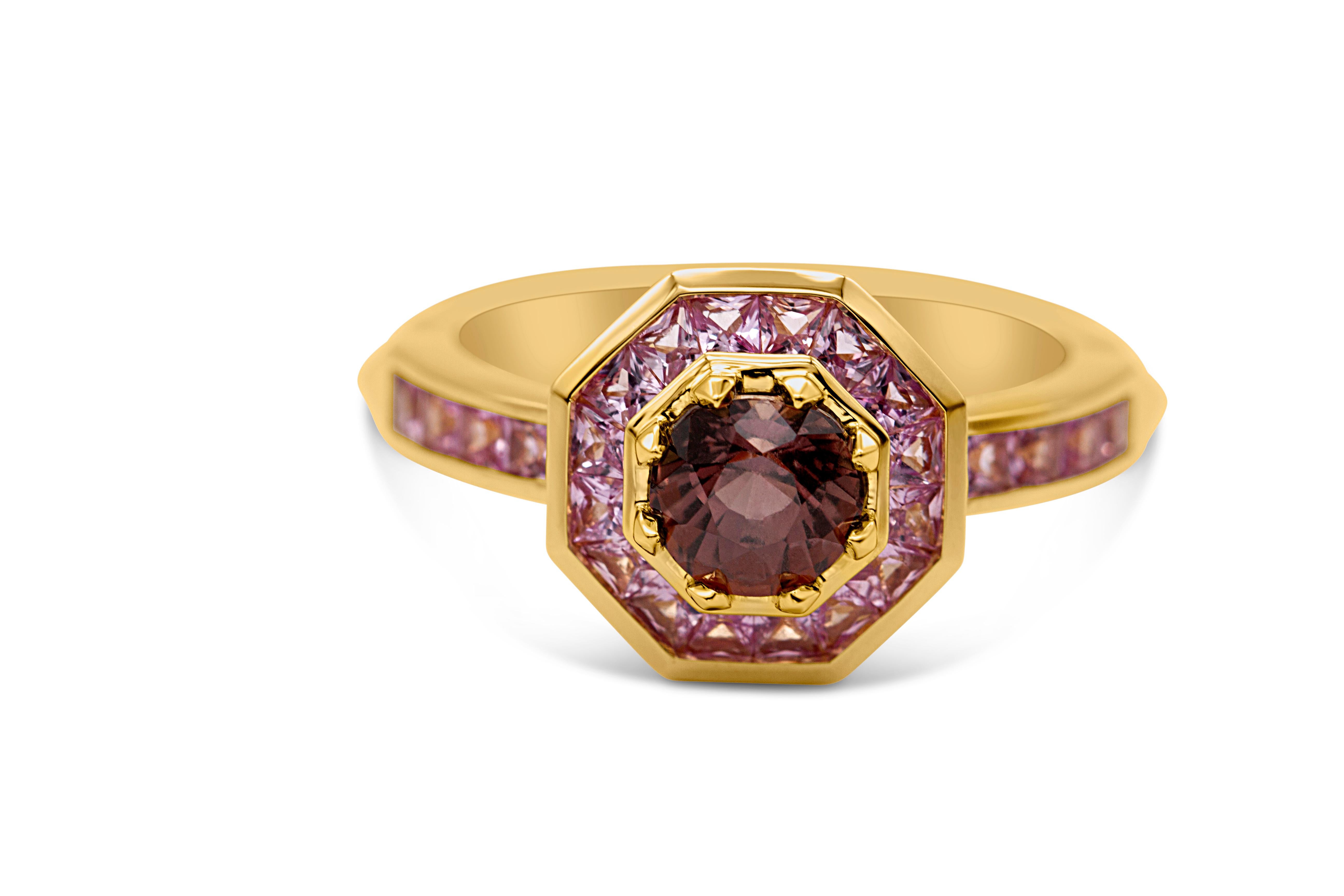 This ring is one of a kind.

18ct yellow gold with a 5.9 mm X 5.5 mm 1.06ct oval cut, colour-changing sapphire. The central stone changes with the light, revealing shades of deep red through to orange, framed by channel set pink sapphires on the