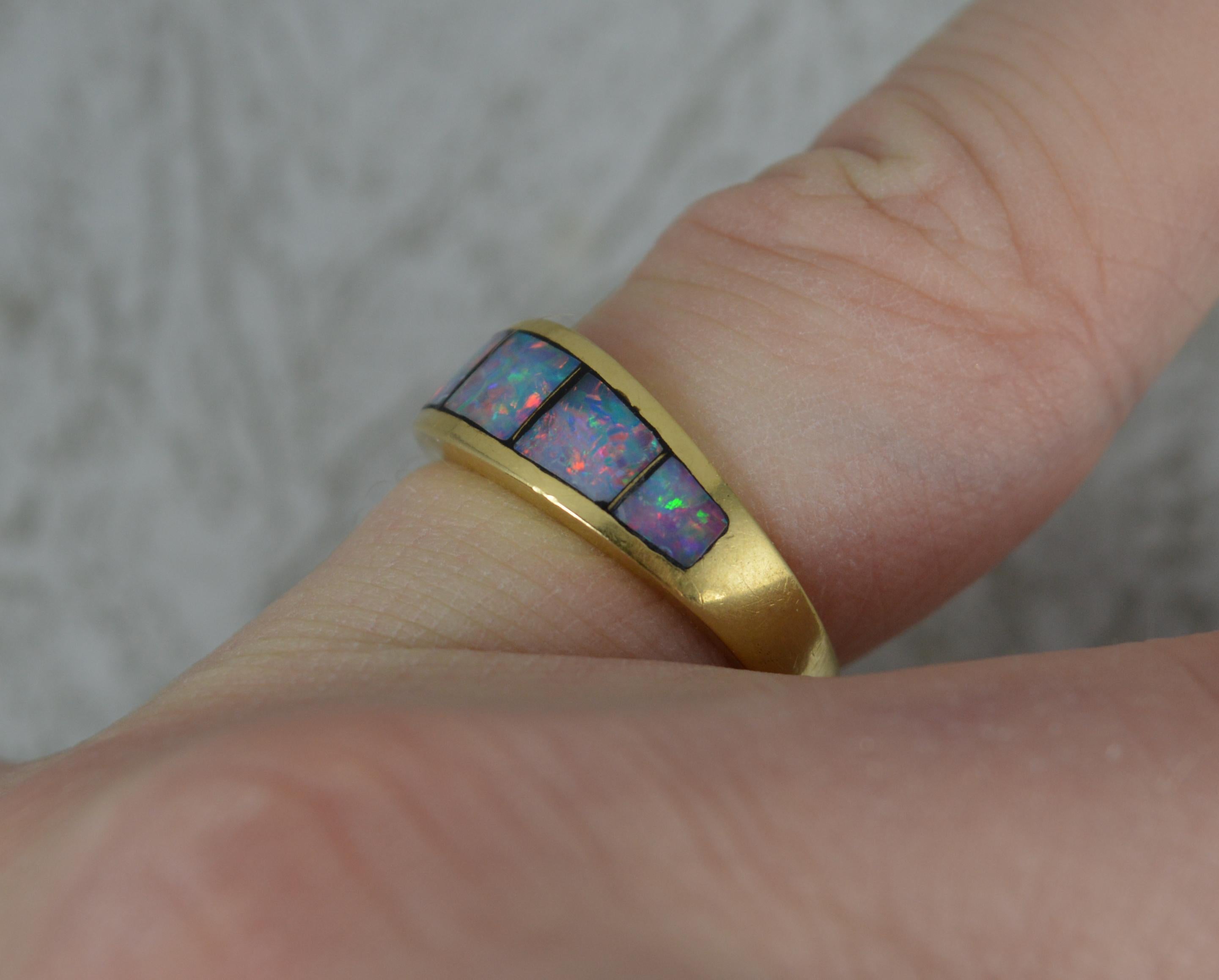A superb opal triplet stack band ring.
Solid 18 carat yellow gold example.
Set with five pieces of opal triplet, each full of colour.
17mm spread of stones. 6.5mm wide band to front.

CONDITION ; Very good. Clean, solid and circular shank. Well set