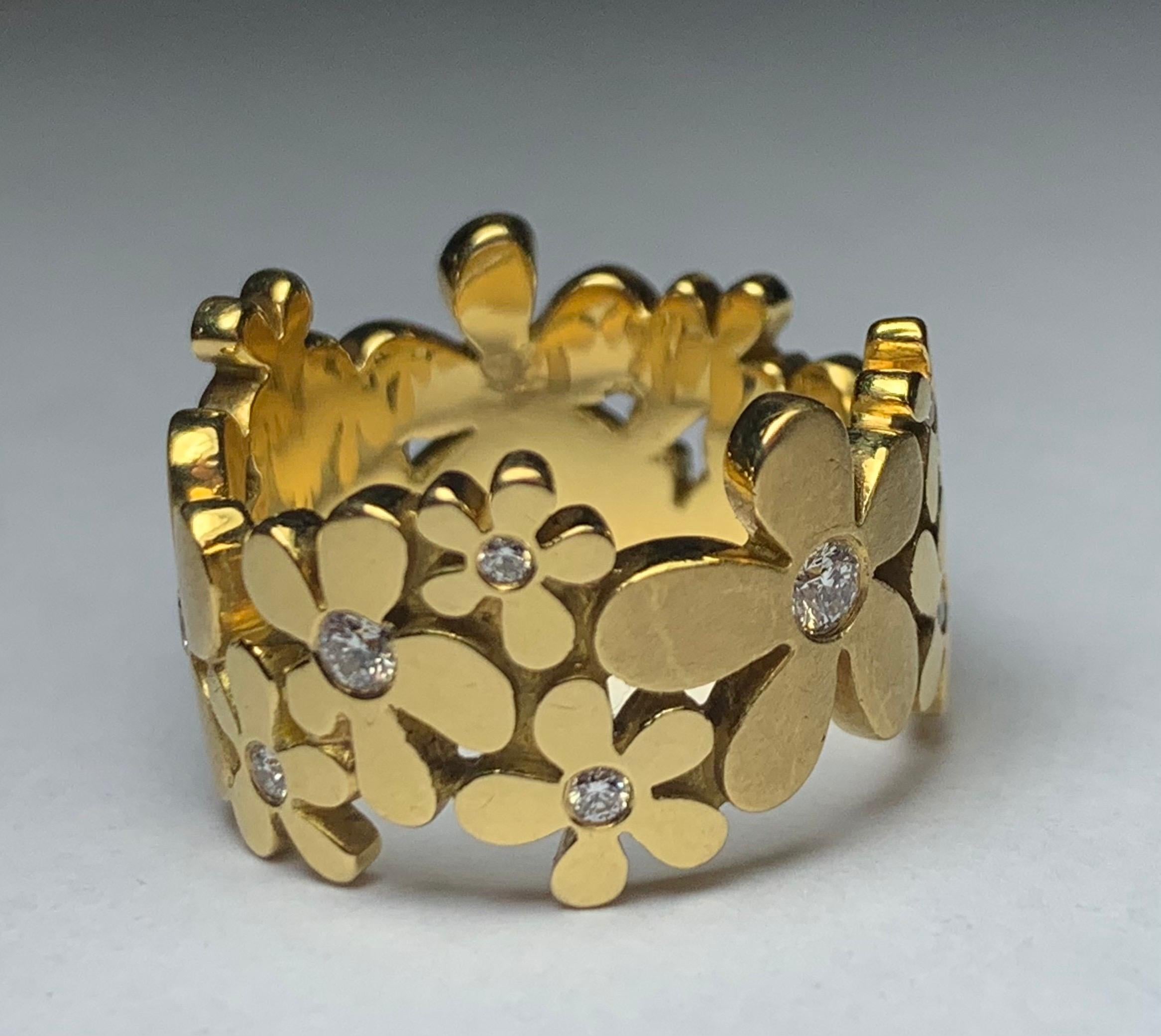 A contemporary 18ct gold ring designed as daisies and set with 14 brilliant-cut diamonds 