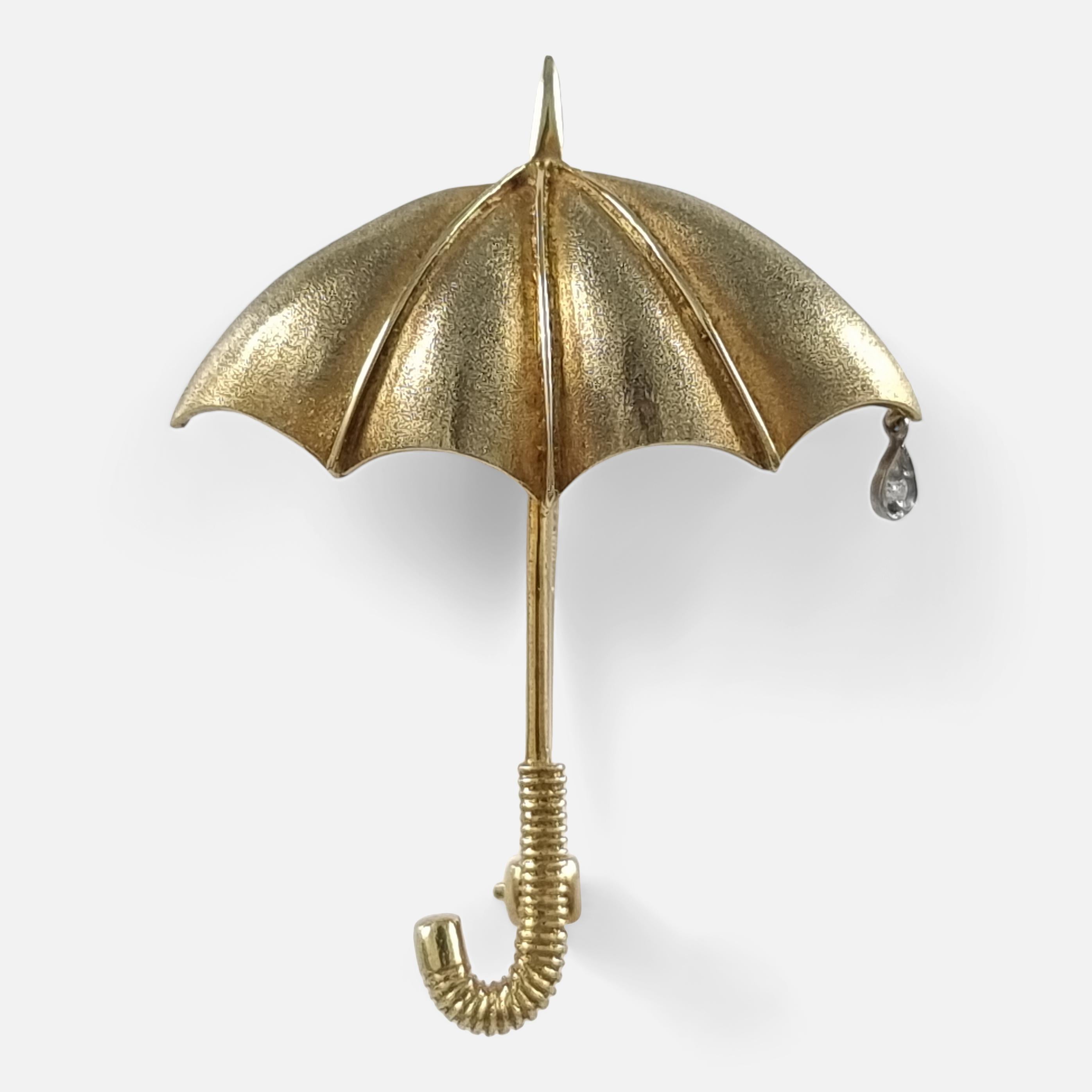 An E. Wolfe & Co. novelty brooch, masterfully created in 18ct gold. This charming umbrella-shaped brooch boasts a unique combination of matte and polished finishes. Its handle is intricately designed with reeded detailing, while the canopy's tip