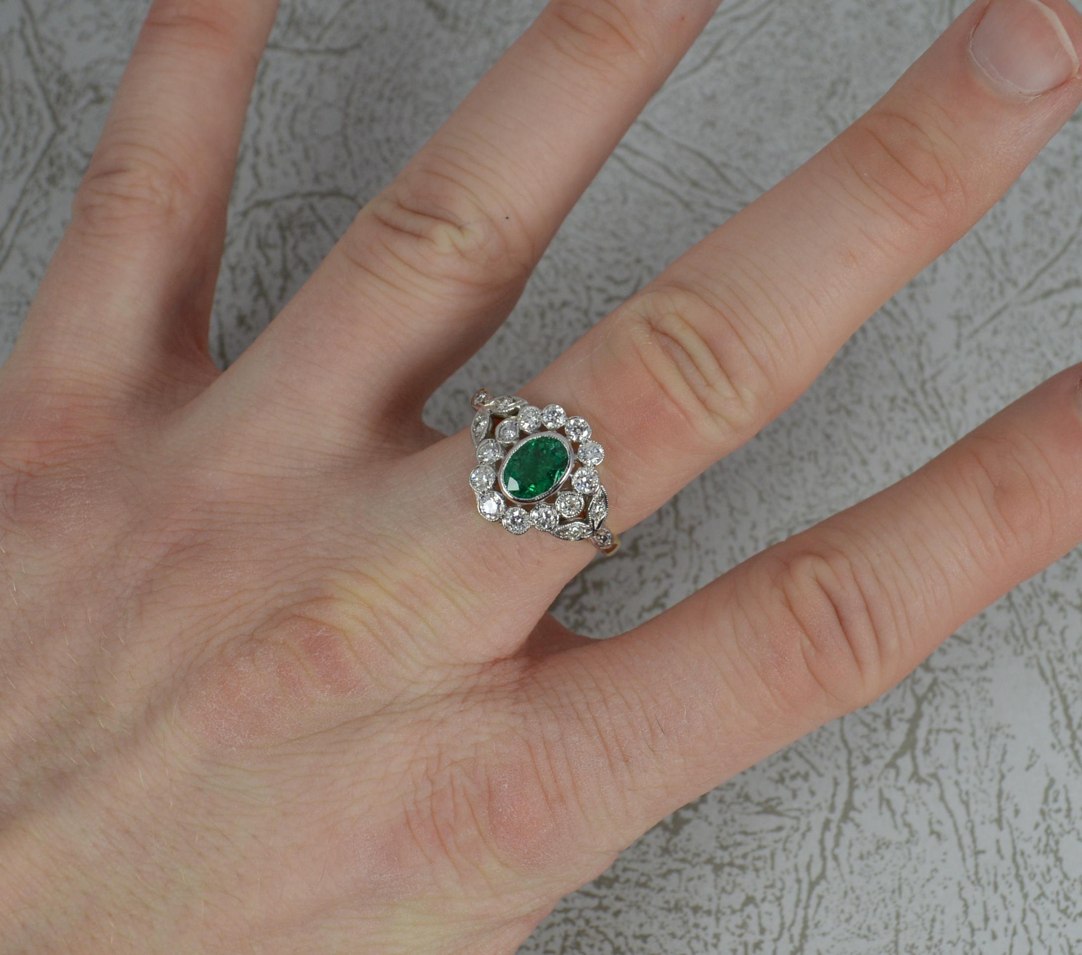 A stunning Emerald and Diamond cluster ring.
Modelled in 18 carat yellow gold with a platinum head setting..
Designed with a natural emerald to centre in full grain bezel setting. 7.3mm x 5.4mm approx.
Surrounding is a full border of smaller round