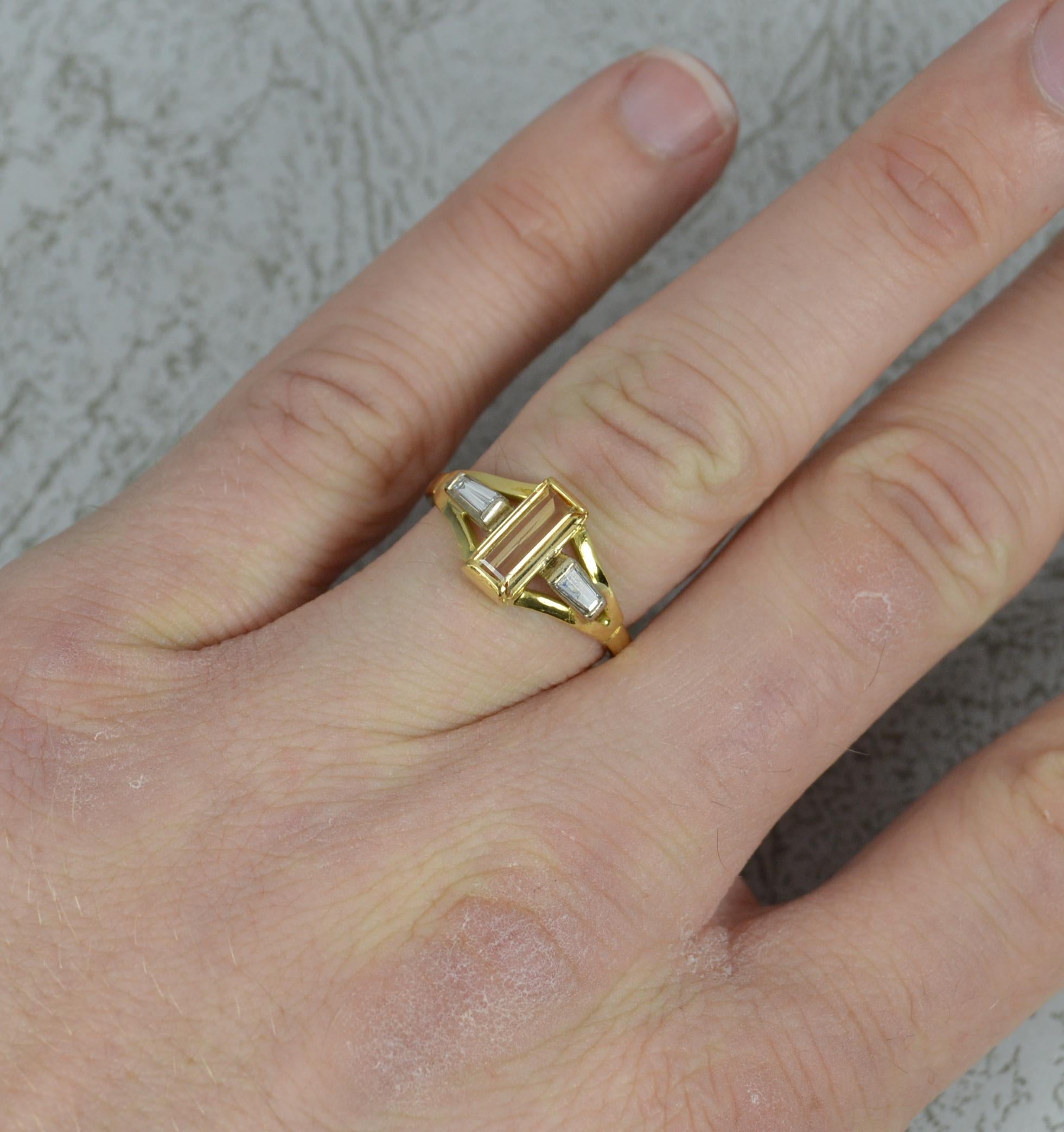 A stunning Topaz and Diamond ring in 18ct Gold.
​4mm x 8.5mm emerald cut gold topaz to centre in tension setting. Each side set with a tapered baguette cut diamond.
Simple yet stylish example. Well made.

CONDITION ; Excellent. Clean and solid