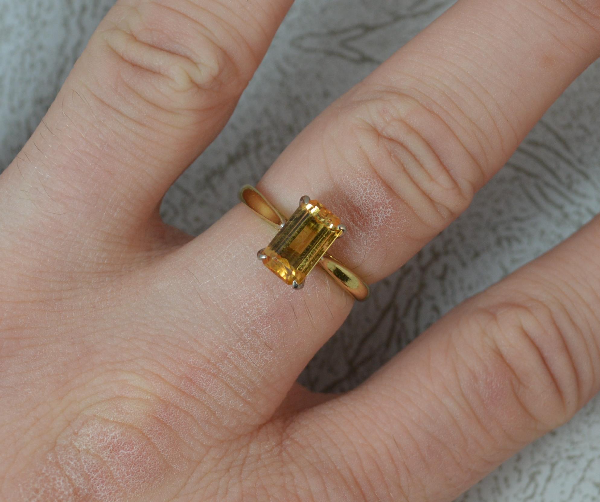 A stunning Topaz solitaire ring in 18ct Gold.
SIZE ; N UK, 6 3/4 US
​Single stone, emerald cut in four white gold claw setting.
5.2mm x 9.1mm golden yellow topaz. Protruding 6mm off the finger.

CONDITION ; Excellent. Clean and solid shank. Well set