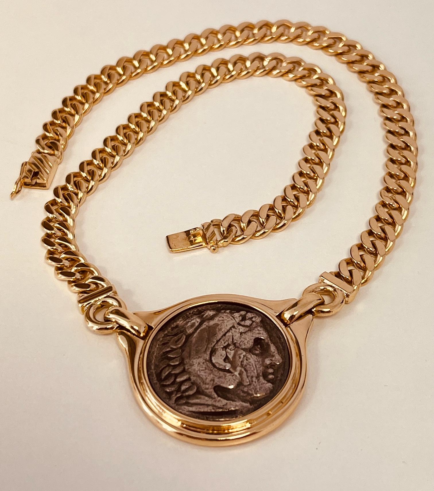 A 18ct gold graduated curb link necklace centring a reproduction of an antique Alexander The Great silver coin. This coin was made using an ancient Greek technique. Circa 1980s. 29cm length. Weight: 76 grams. Stamped 750 to the tongue. Price: