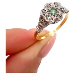 Anillo de oro y platino de los años 20 con esmeralda y diamantes engastados en forma de estrella y racimo de margaritas
