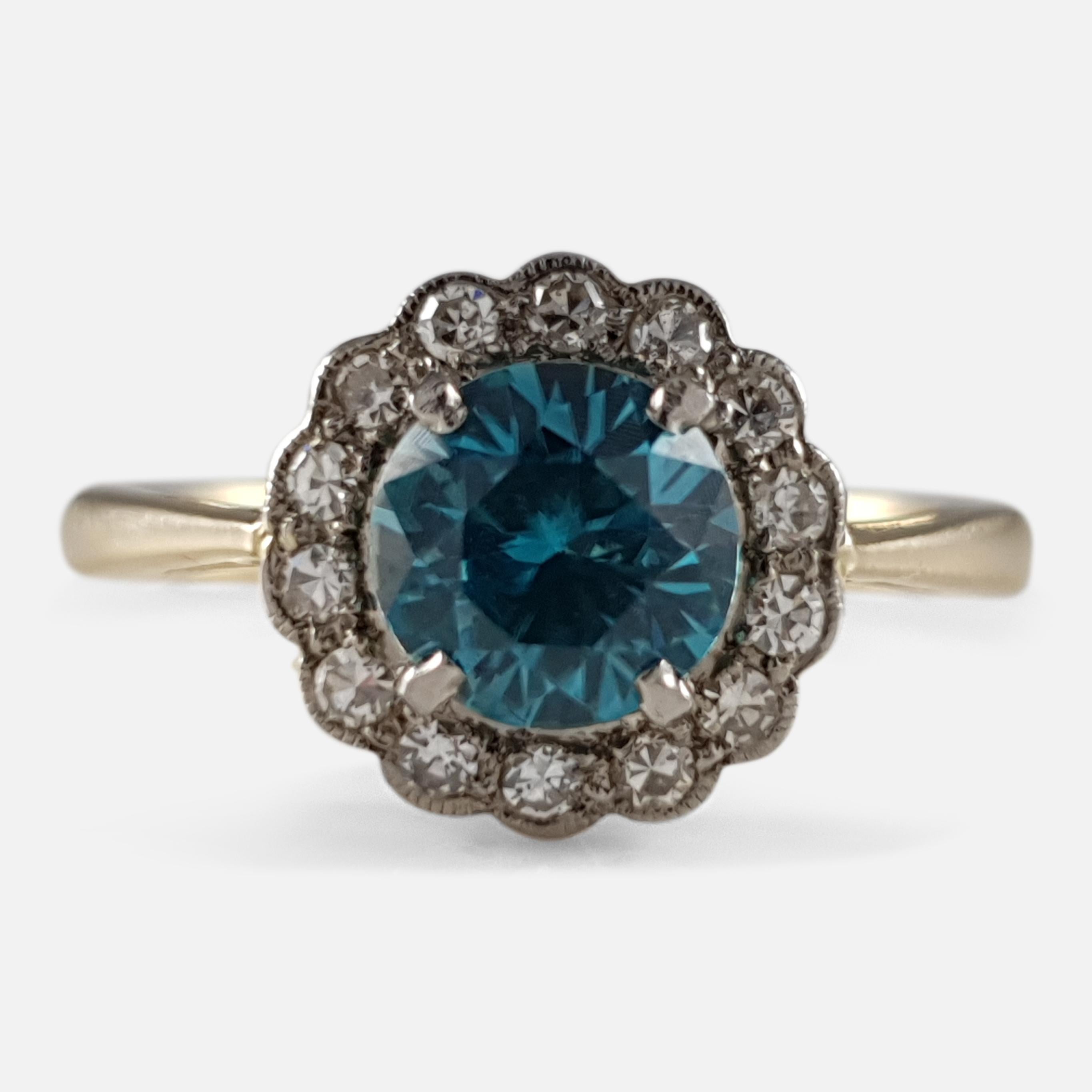 An 18ct yellow gold and platinum zircon and diamond daisy cluster ring featuring a 1.18ct blue zircon surrounded by 14 single cut diamonds totaling approximately 0.21ct in a milgrain setting.

• Assay: Stamped '18ct PLAT' to denote 18 carat gold and