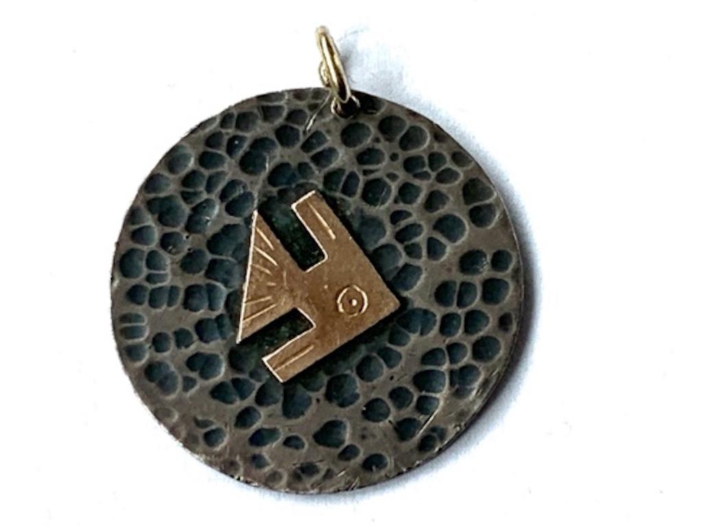 18ct Gold & Silver 925 Peruvian handmade Pendant 
Hand hammered finish 
with central 18k gold character - Fish ?
the Bolt ring applied is 9ct gold

Signed by VICKY 
Era late 1960s.
Weight 6.24 grammes