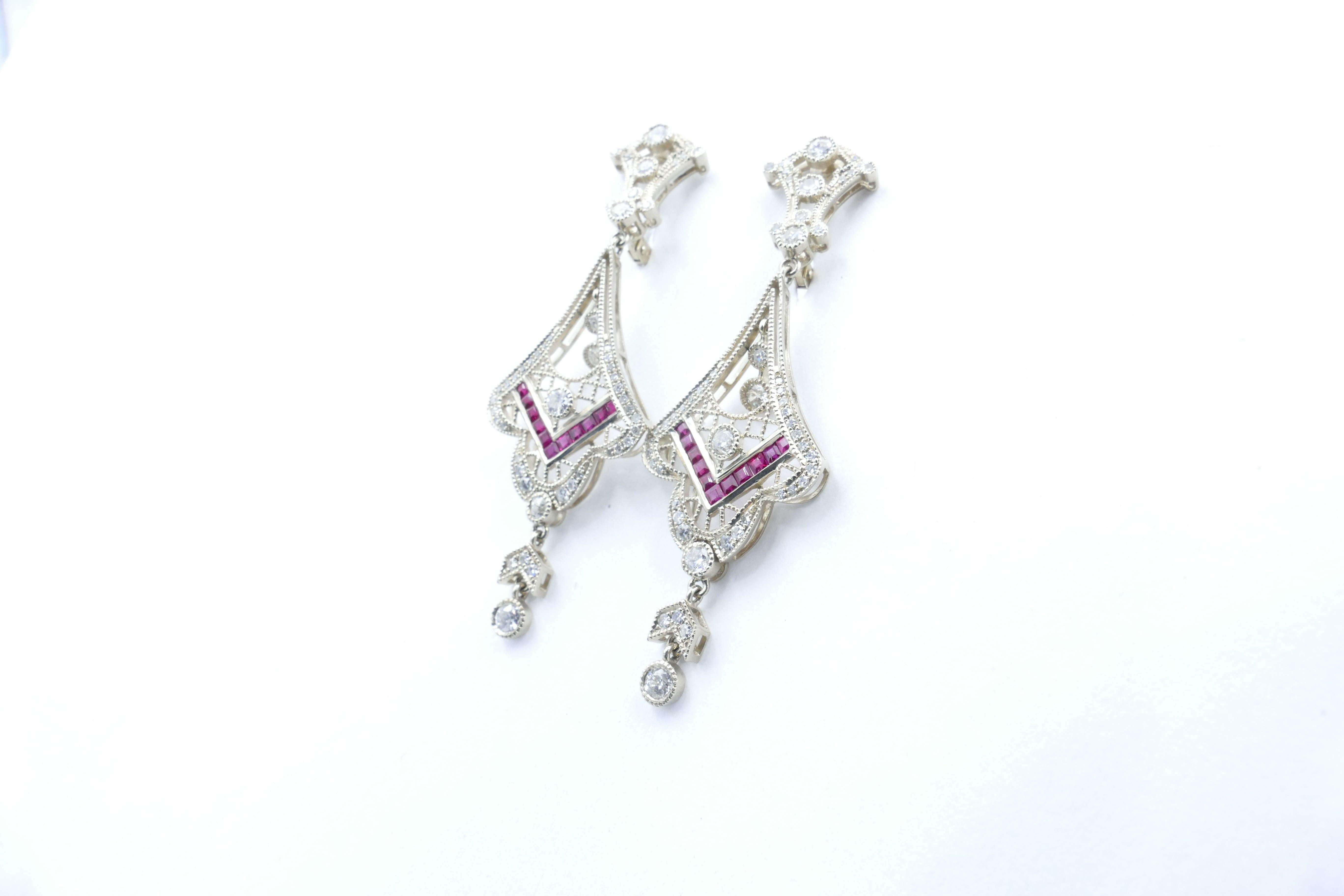 There are a massive 108 Diamonds in these gorgeous modern Drop Earrings.
The Colour is H/I with Clarity SI1-I1, grain/bezel set with millegrain detail.
In the Centre are 22 Rubies of purplish-red, eye-clean clarity, French carre cut, channel set.
A