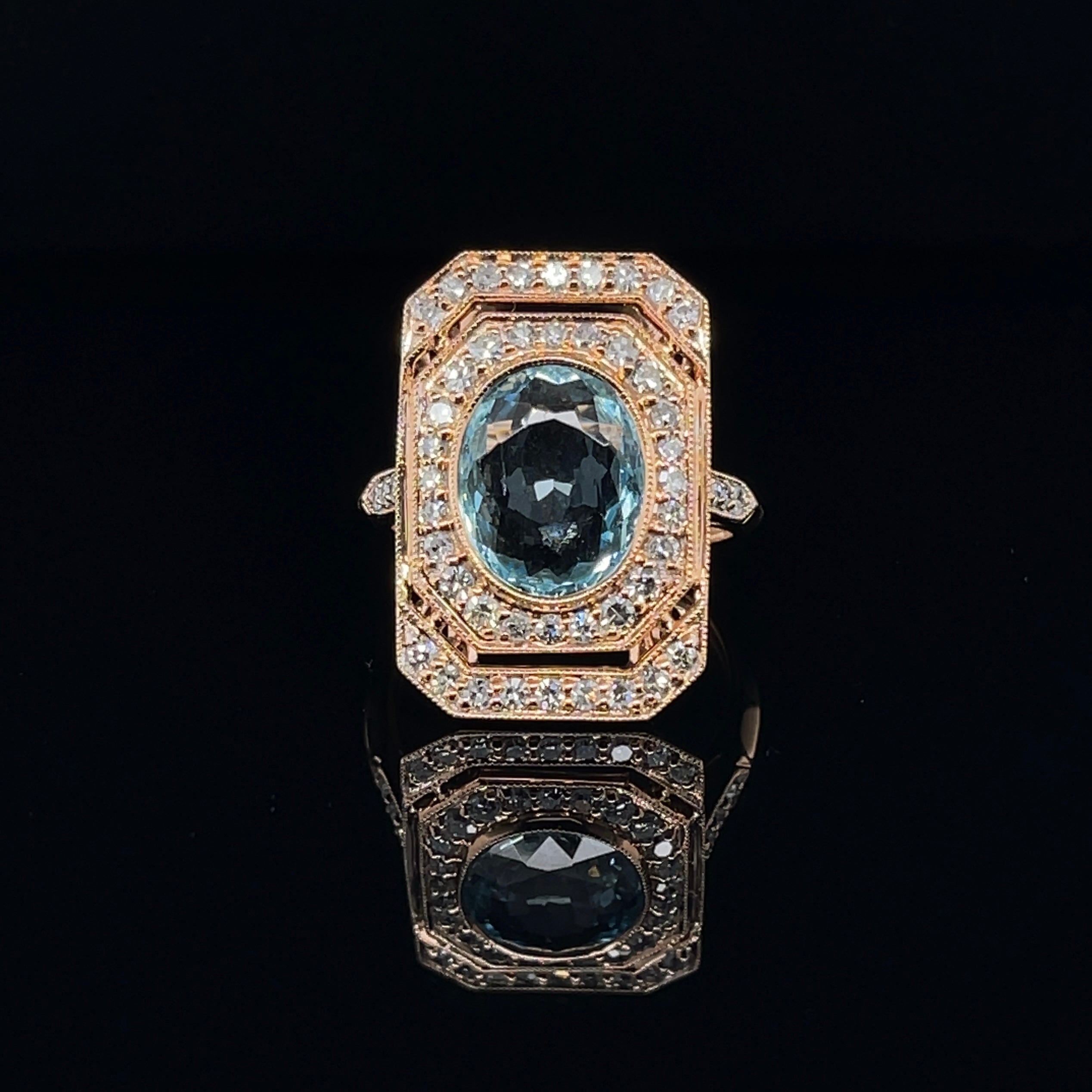 Oval shaped aquamarine, crafted with eighteen karat rose gold, featuring a beautiful selection of forty-eight bead set natural single cut diamonds, also one rub over set oval shaped natural aquamarine. complimented with a polished finish