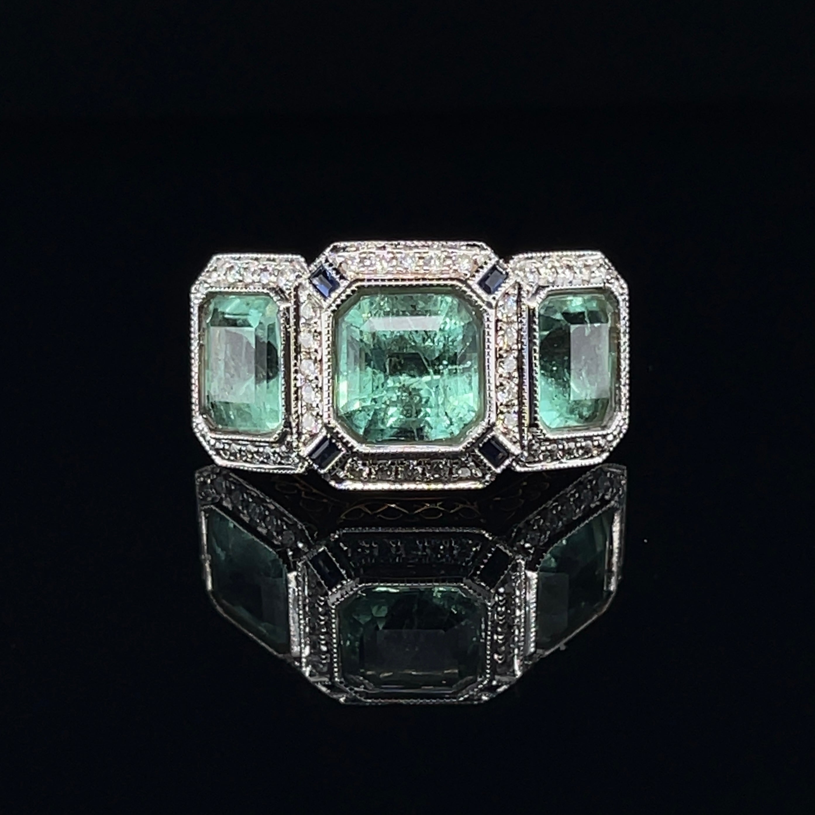 Colombian (based on my opinion) Emerald cut emeralds, crafted in eighteen karat rose gold, half round, tapered shank with closed back bezel settings with single halo surrounds, featuring a stunning selection of  fifty-four claw set round brilliant