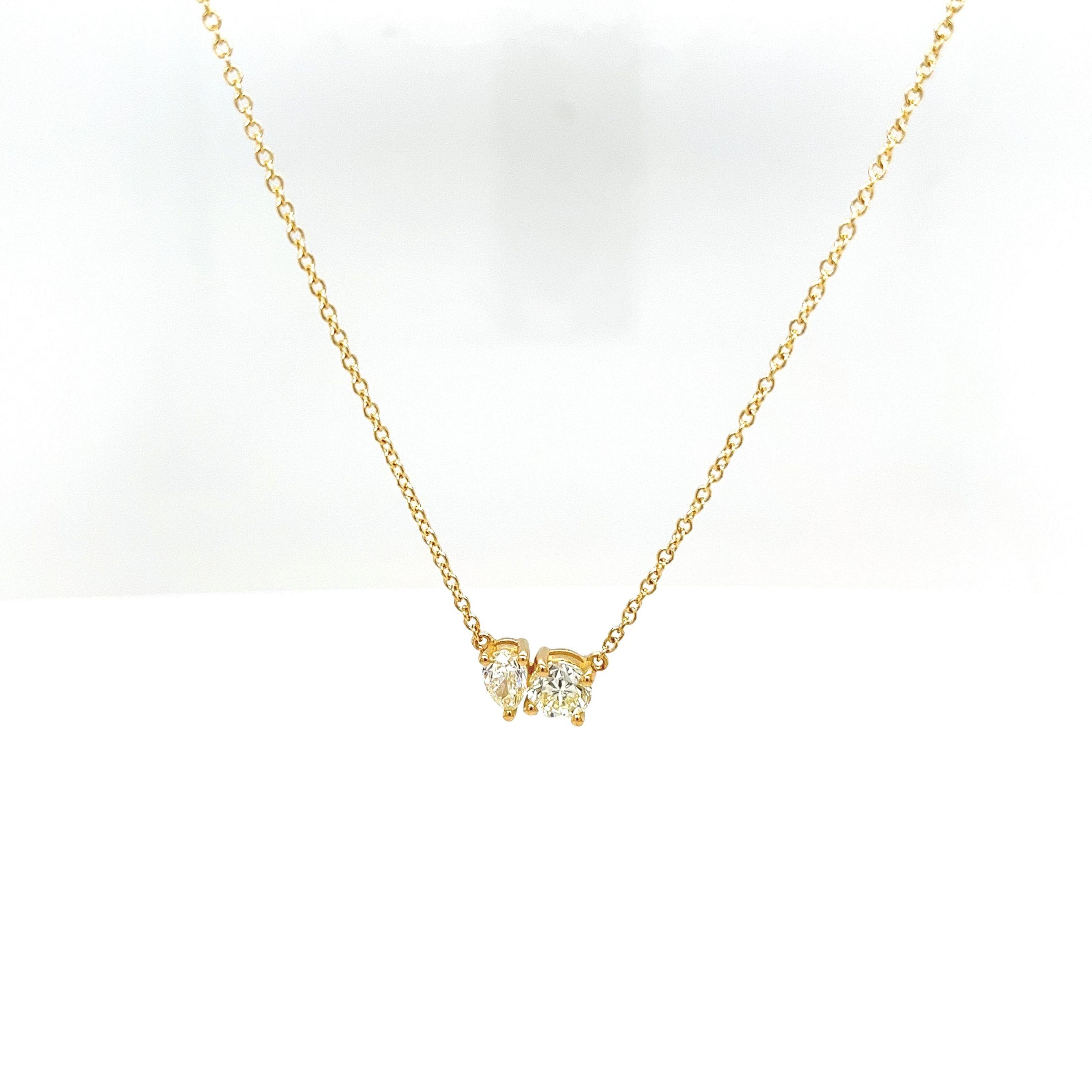 Ce magnifique pendentif Toi Et Moi est serti d'un diamant poire de 0,30ct et d'un diamant rond de taille brillant de 0,50ct de couleur M-N et de pureté VS en or jaune 18ct. 
Le pendentif est suspendu à une chaîne en or jaune 18ct qui mesure 18